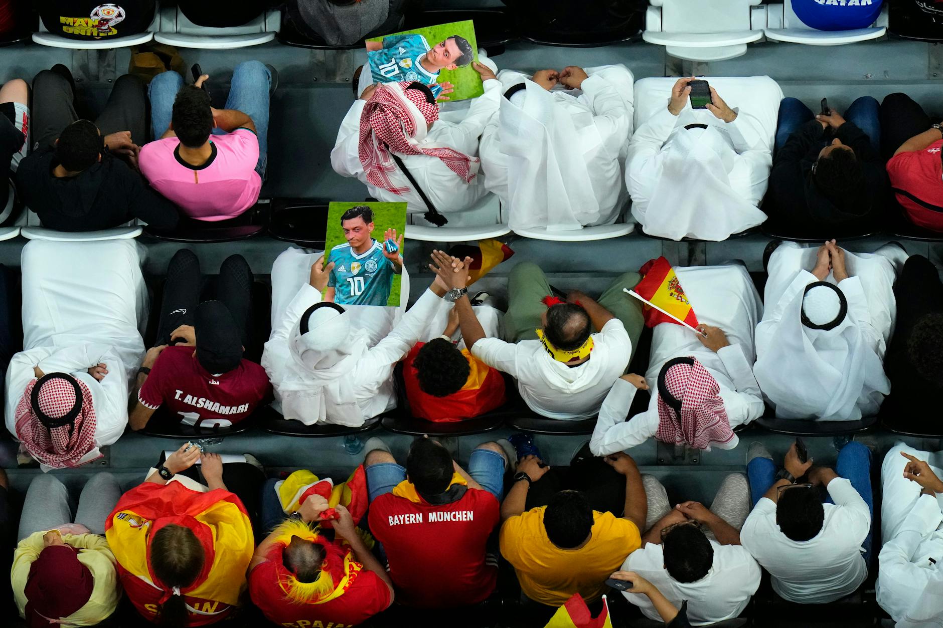 Zuschauer halten beim Spiel Deutschland gegen Spanien Bilder des früheren deutschen Fußball-Nationalspielers Mesut Özil in die Höhe 