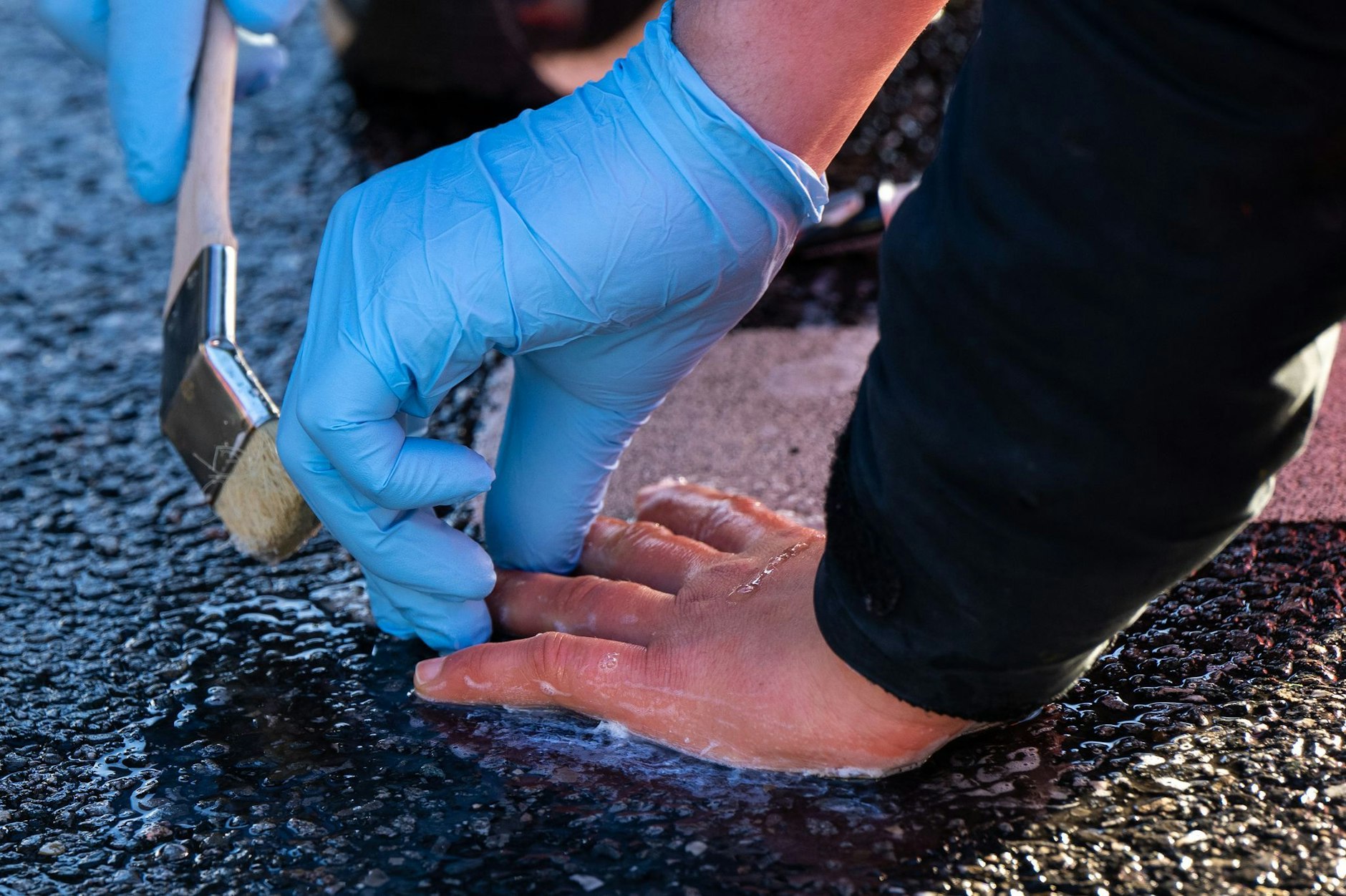 Ein Polizisten löst die Verklebung, mit der sich ein Klimaaktivist der Umweltschutzbewegung «Letzte Generation» geklebt hatte.