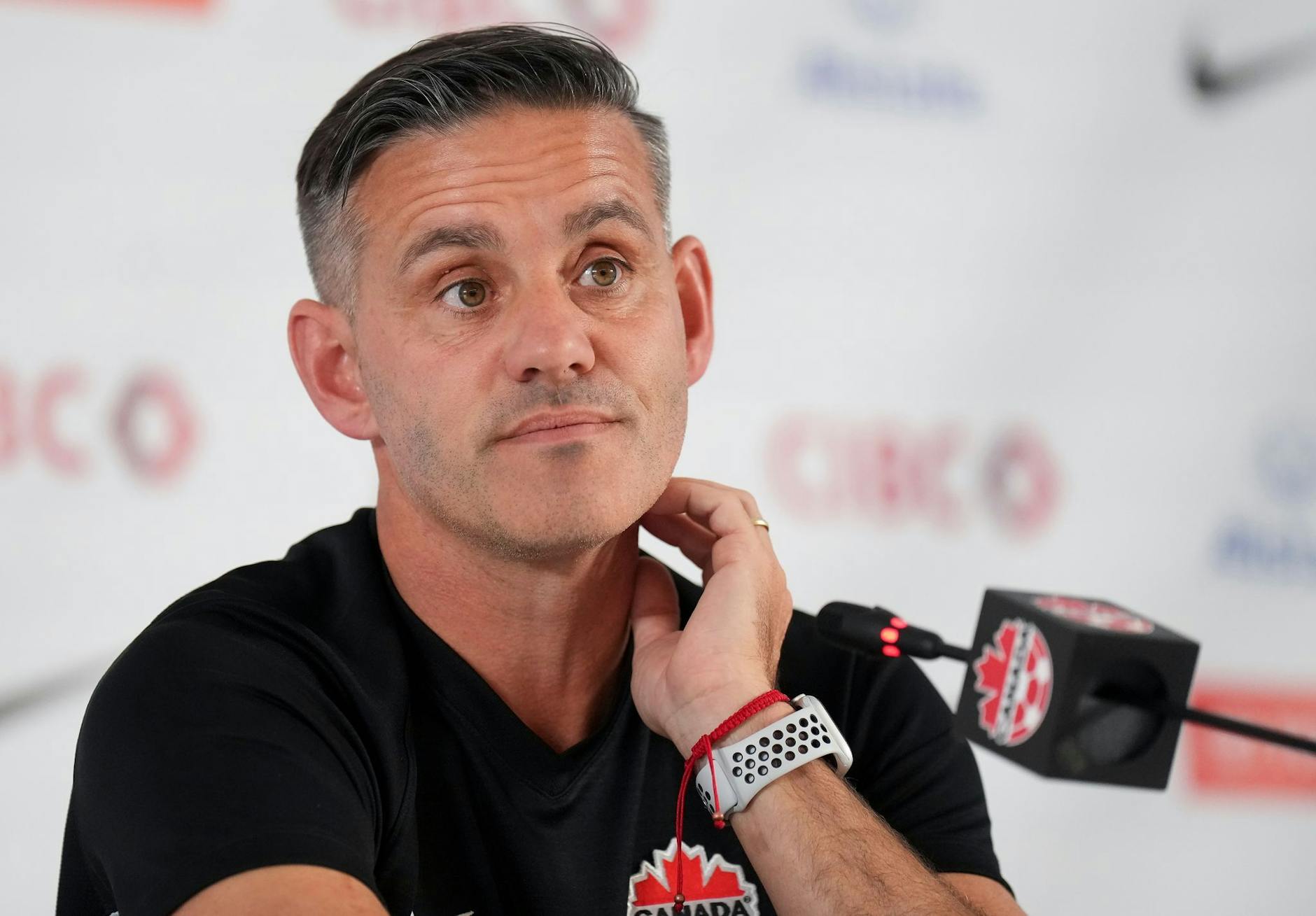 Kanadas Trainer John Herdman sitzt während einer Pressekonferenz auf dem Podium. a ZUMA Press/dpa