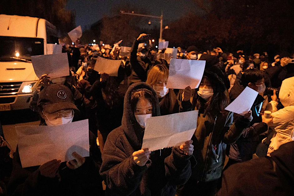 Demonstranten halten leere Papiere hoch, während sie protestieren.
