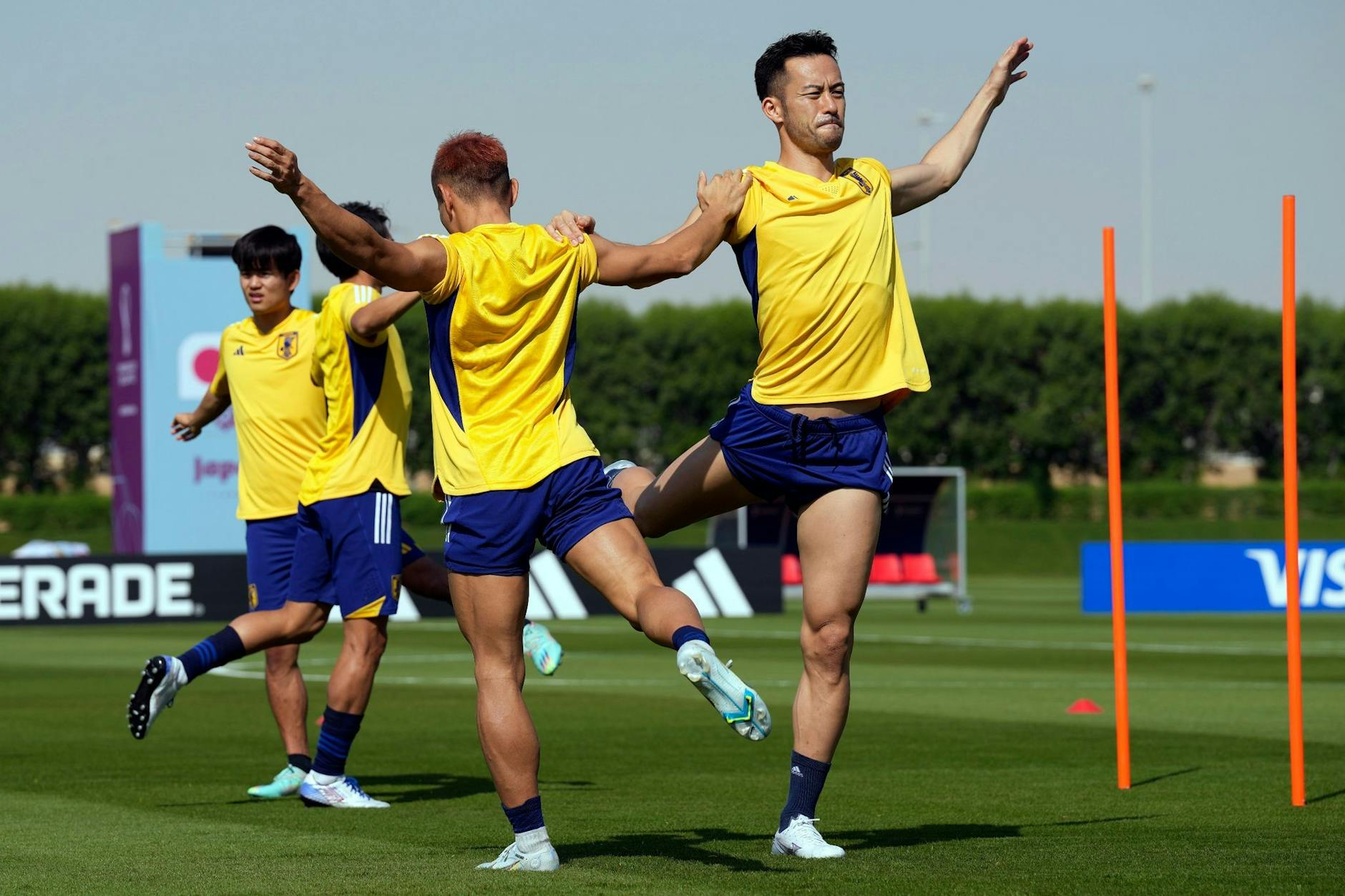 Japans Maya Yoshida (r) und Yuto Nagatomo wärmen sich mit ihren Mannschaftskameraden auf.