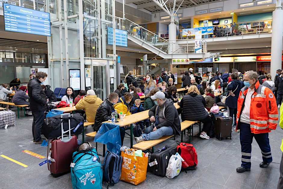 ARCHIV - Geflüchtete aus der Ukraine sitzen nach der Ankunft im Flughafen Erfurt-Weimar und werden von Helfern betreut.  