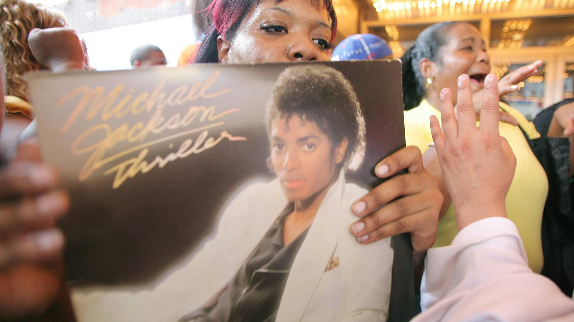 2009 starb der King of Pop. Auf einer spontanen Trauerkundgebung in New York zeigen Fans ihr Thriller-Album.