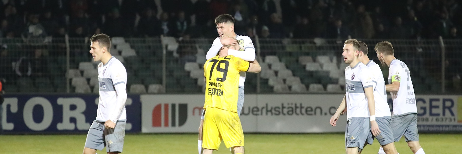Erschöpft, aber glücklich: Während die Dynamo-Kollegen noch gezeichnet vom Kampf sind, herzt BFC-Keeper Kevin Sommer den Ausgleichstorschützen Erlind Zogjani.