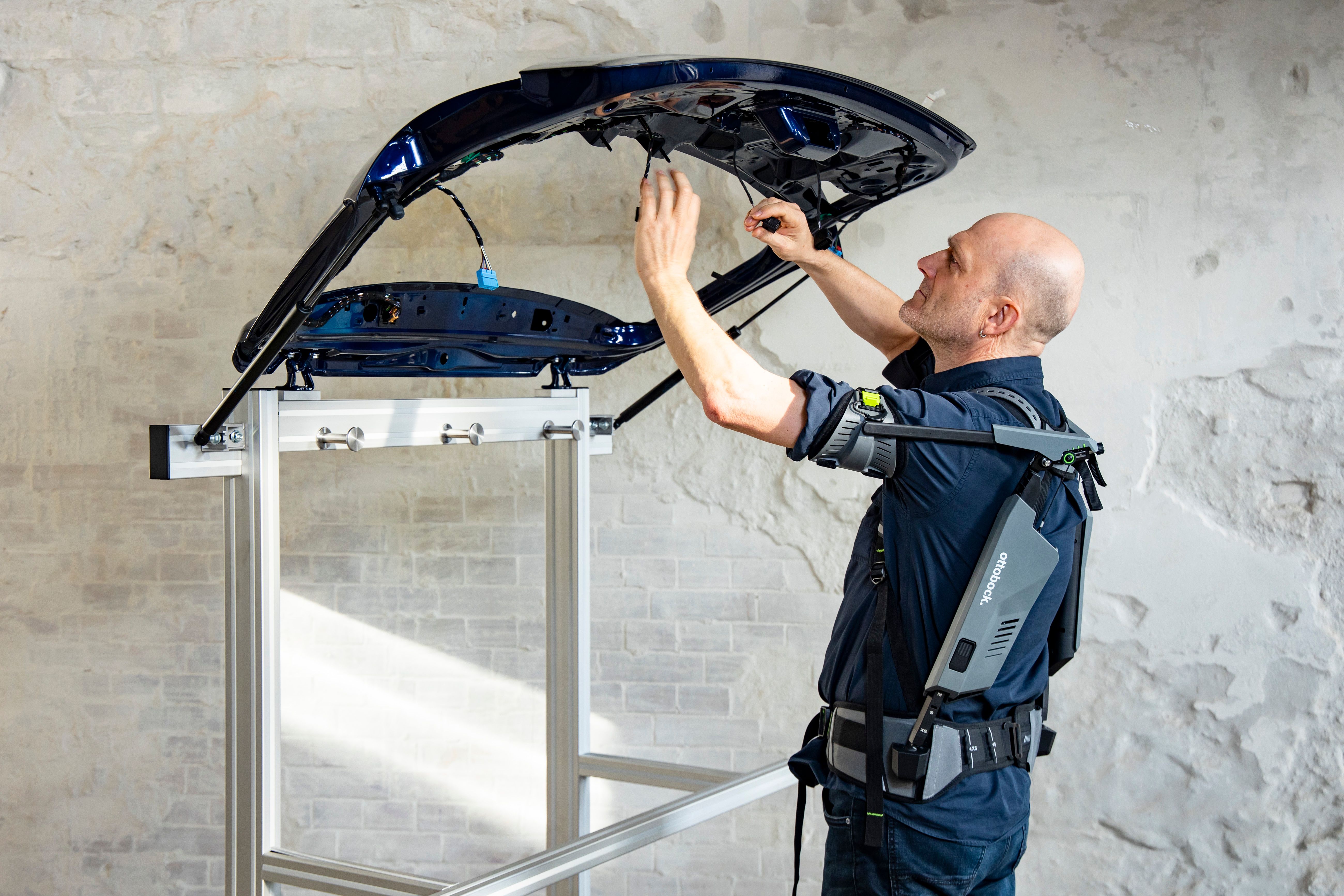 Self-testing on the tailgate of a car: On the assembly line, workers often have to work overhead for hours.