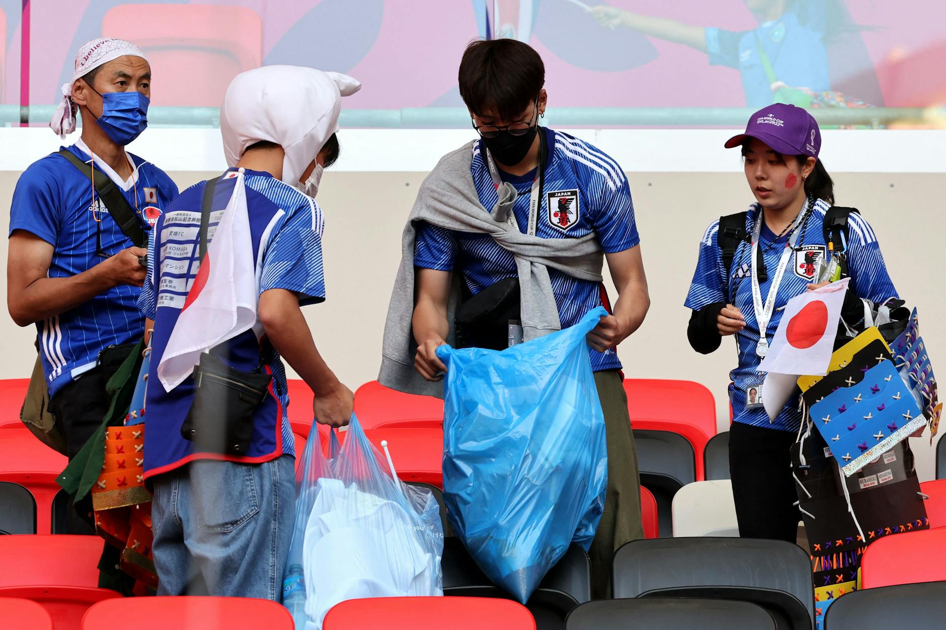 Japanische Fans in Katar räumen nach dem Spiel im Stadion auf. 