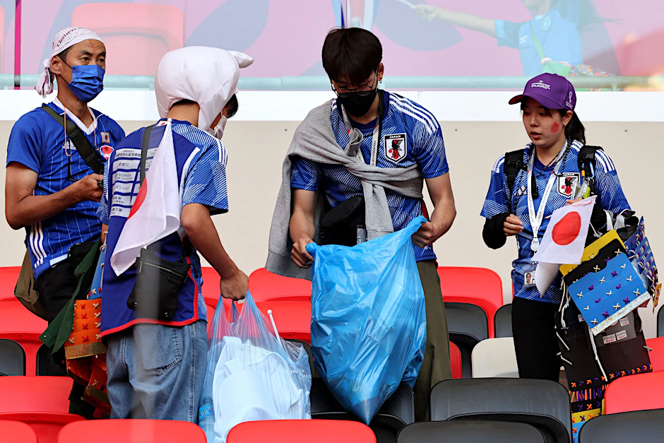 Japanische Fans in Katar räumen nach dem Spiel im Stadion auf.&nbsp;