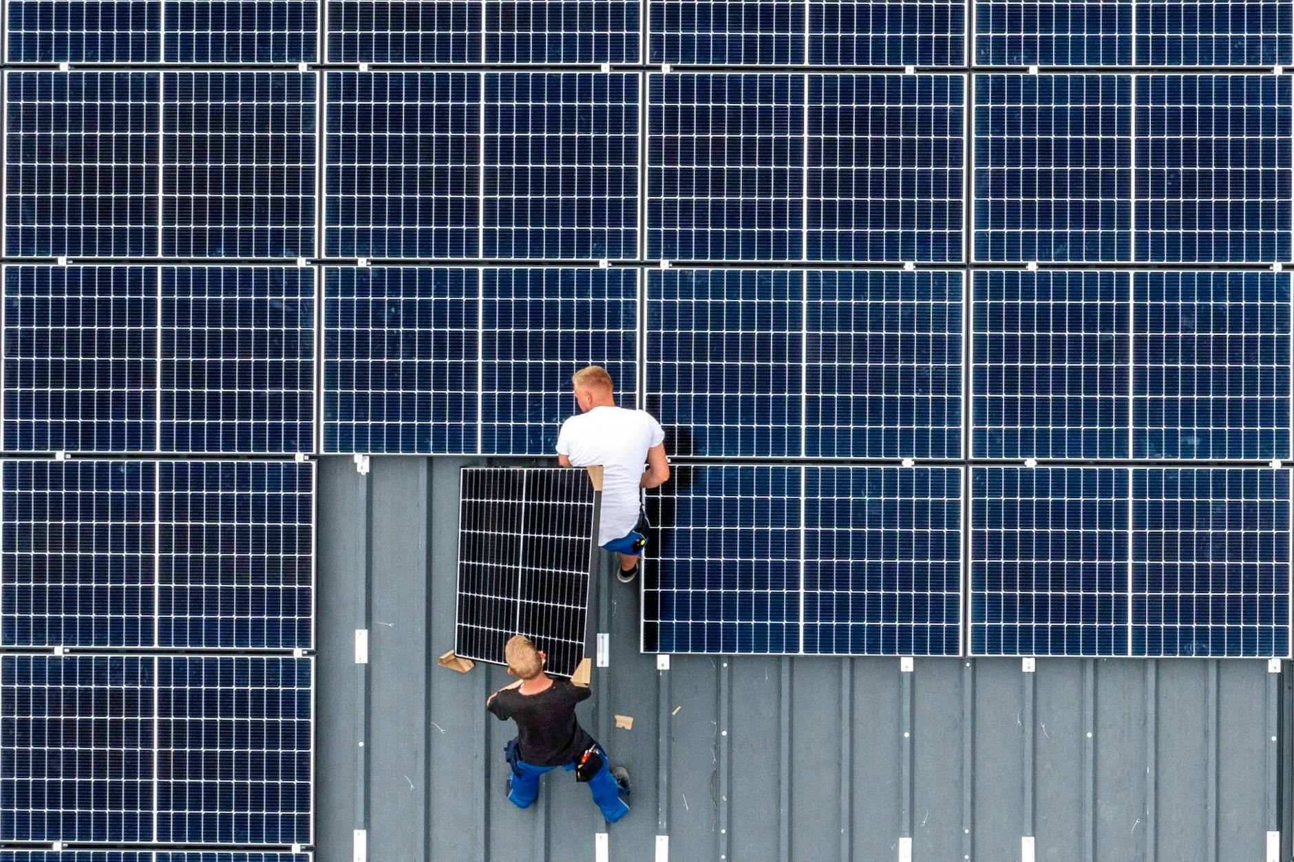 Montage von Solarmodulen auf dem Dach einer Scheune