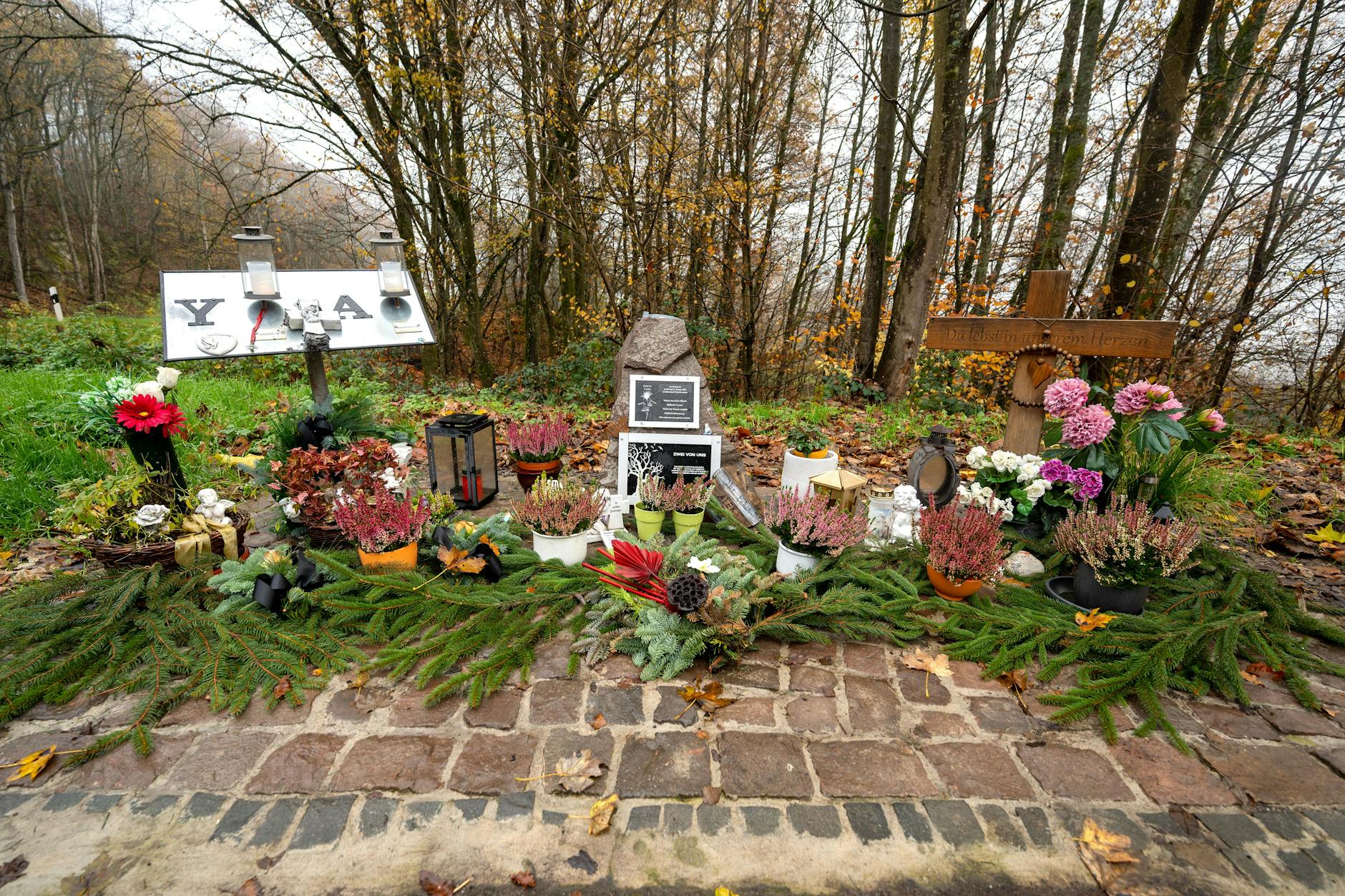 Ein Gedenkstein und Blumen sind in der Nähe des Tatorts an der K22 bei Kusel
