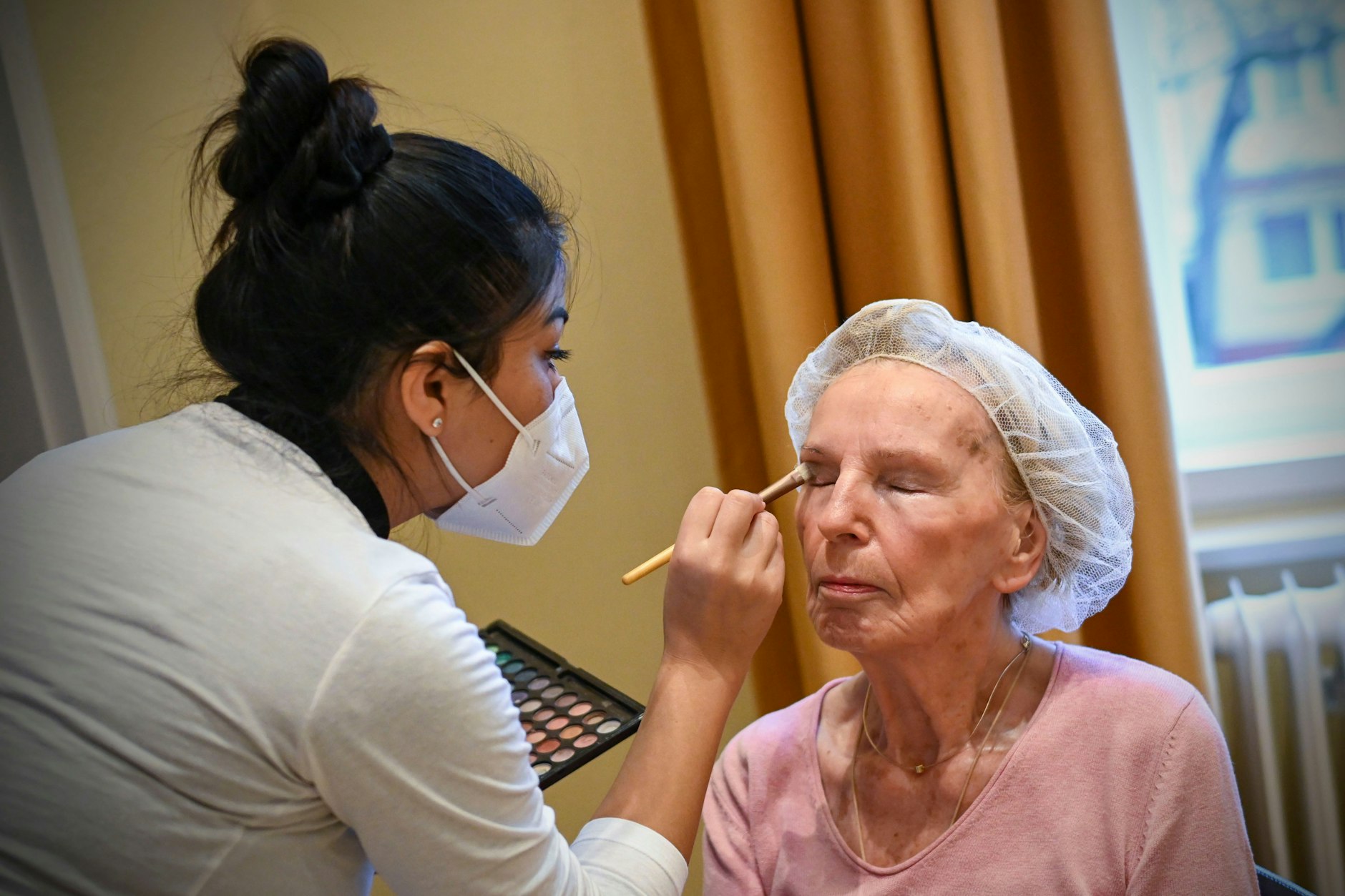 Hannelore Markurt lässt sich von der Kosmetikschülerin Laura Cadima schminken.