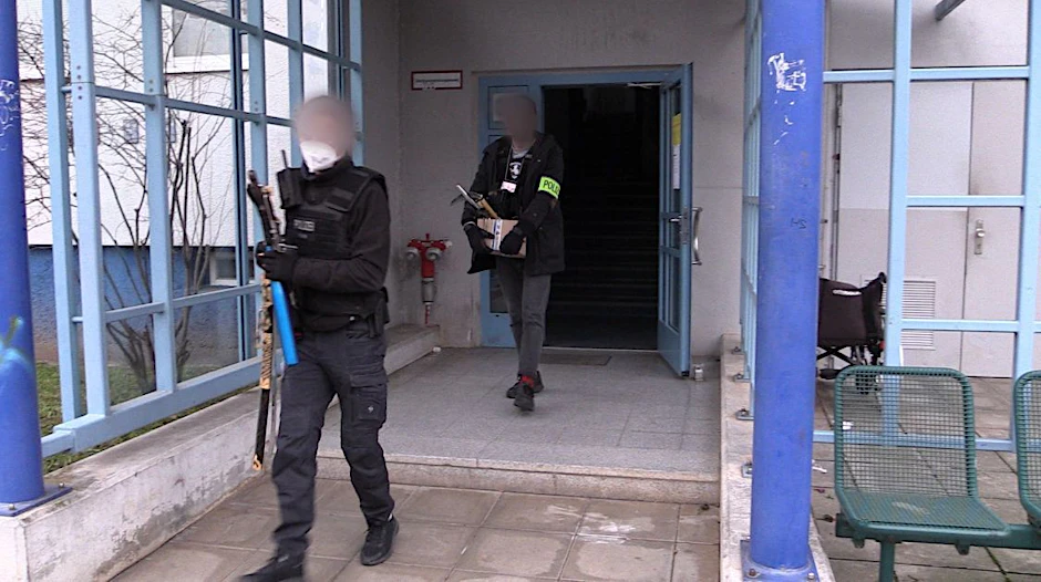 Polizisten verlassen mit beschlagnahmten Beweismitteln nach einer Durchsuchung ein Haus.&nbsp;