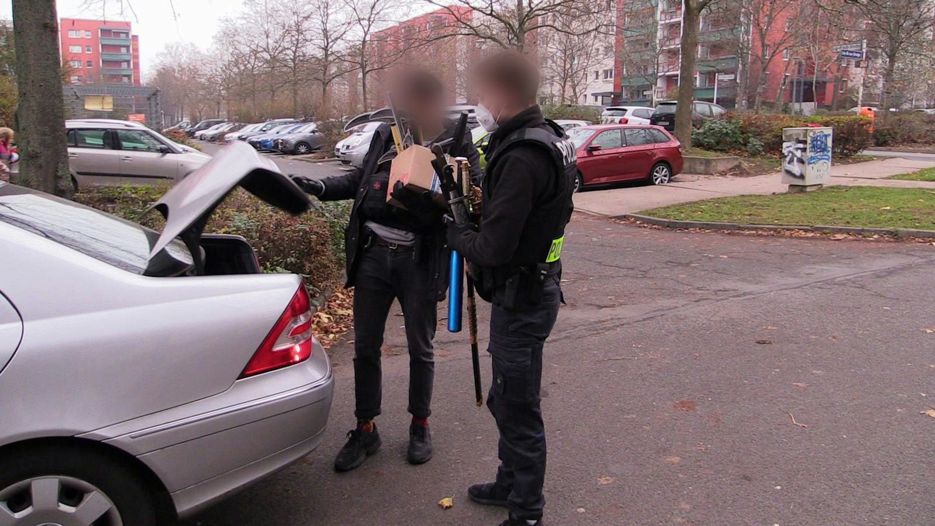 Polizeibeamte  laden bei der Anti-Hass-Razzia&nbsp; beschlagnahmte Säbel, Macheten und Baseballschläger in ihr Zivilfahrzeug. Die Waffen stammen aus einer Wohnung an der Hellersdorfer Lily-Braun-Straße.