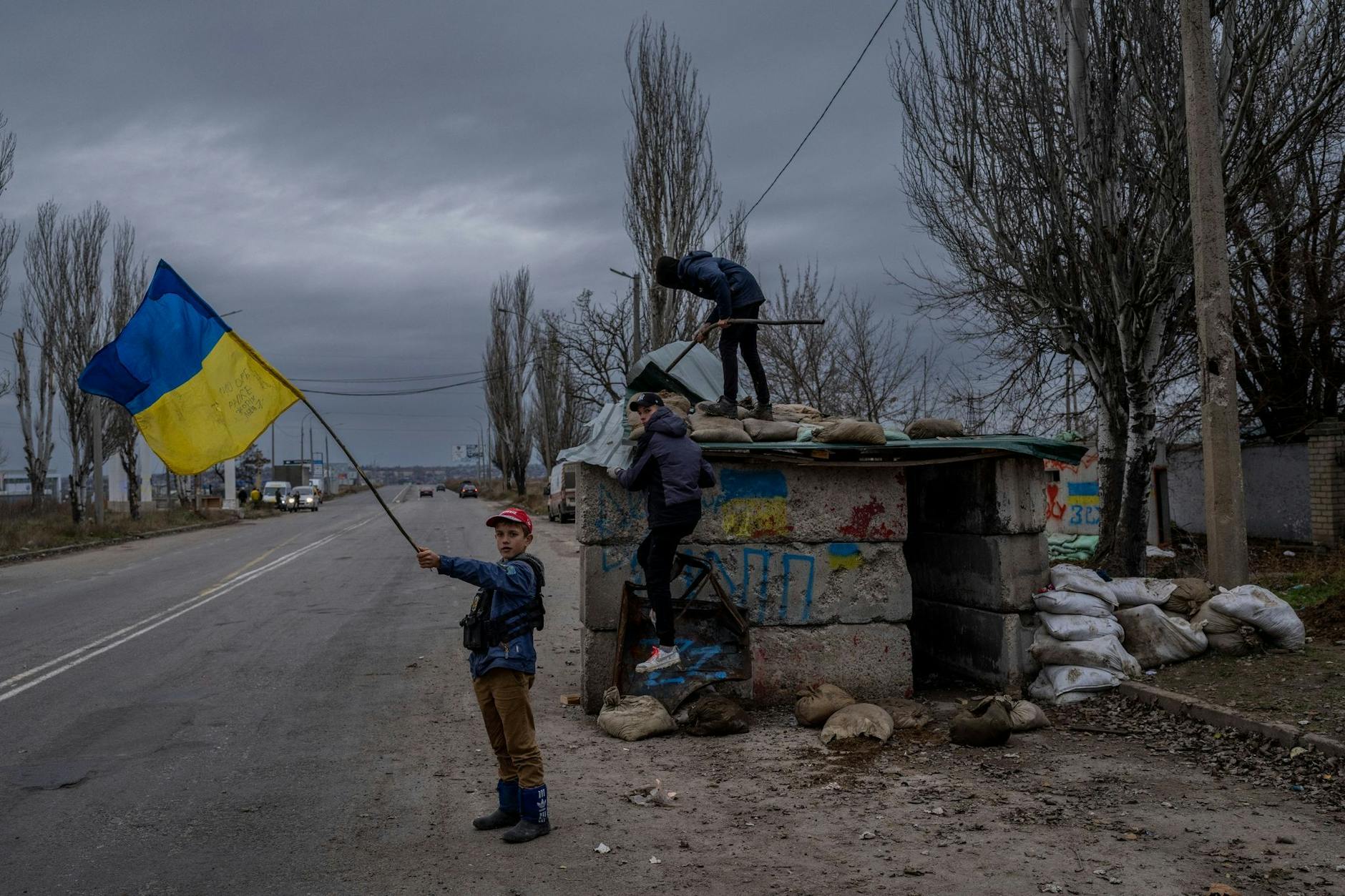dpatopbilder - Ukrainische Kinder spielen an einem verlassenen Kontrollpunkt in Cherson.