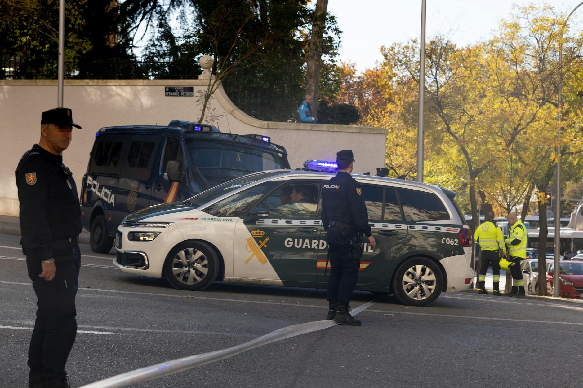 Polizisten und Feuerwehrleute stehen vor der US-Botschaft in Madrid, wo eine Briefbombe eingegangen ist.