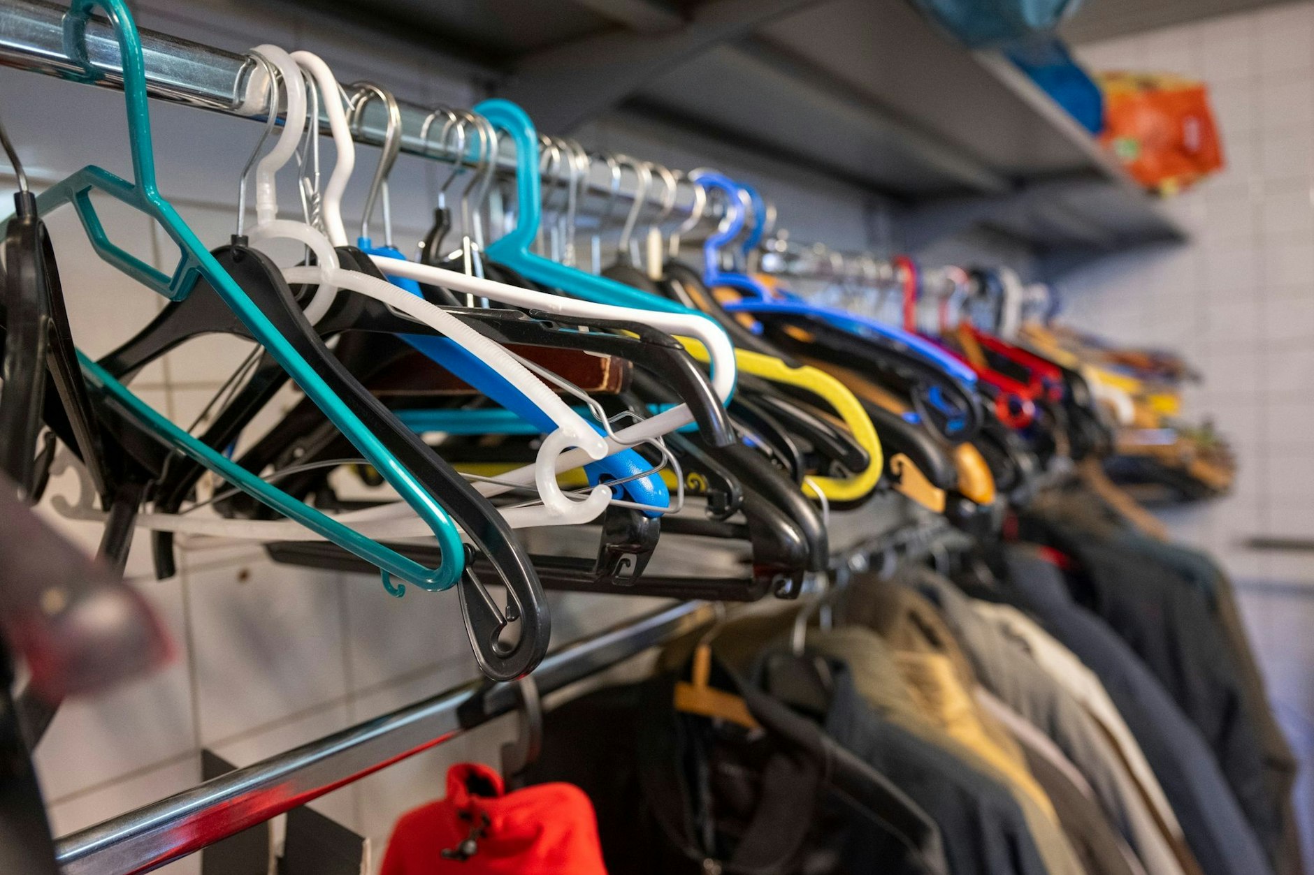 Leere Kleiderbügel hängen an einer Stange in der Kleiderkammer der Berliner Stadtmission.