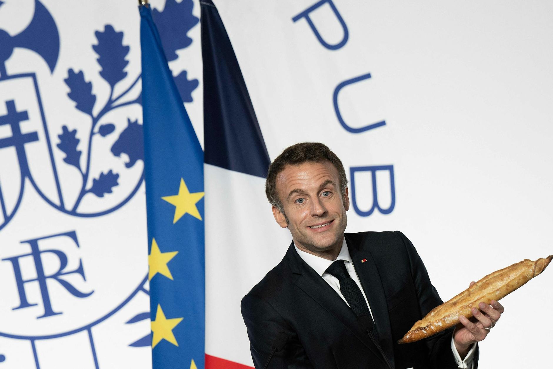 Der französische Präsident Emmanuel Macron mit dem Nationalgebäck