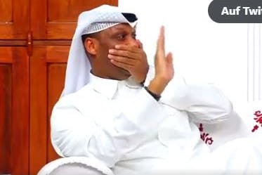 Ein Katarer winkt mit zugehaltenem Mund.