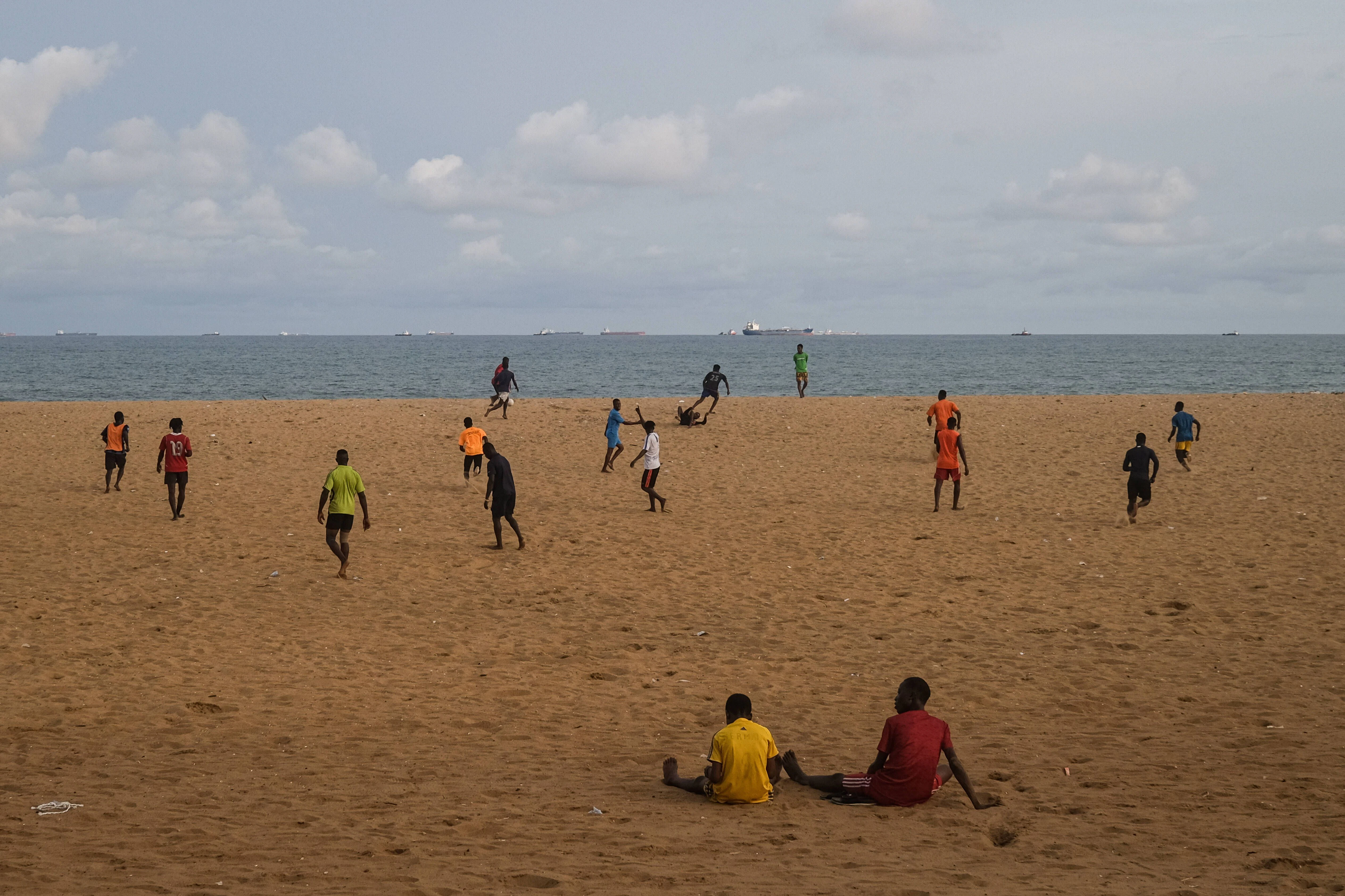 Junge Männer spielen am Strand von Lome Fußball.