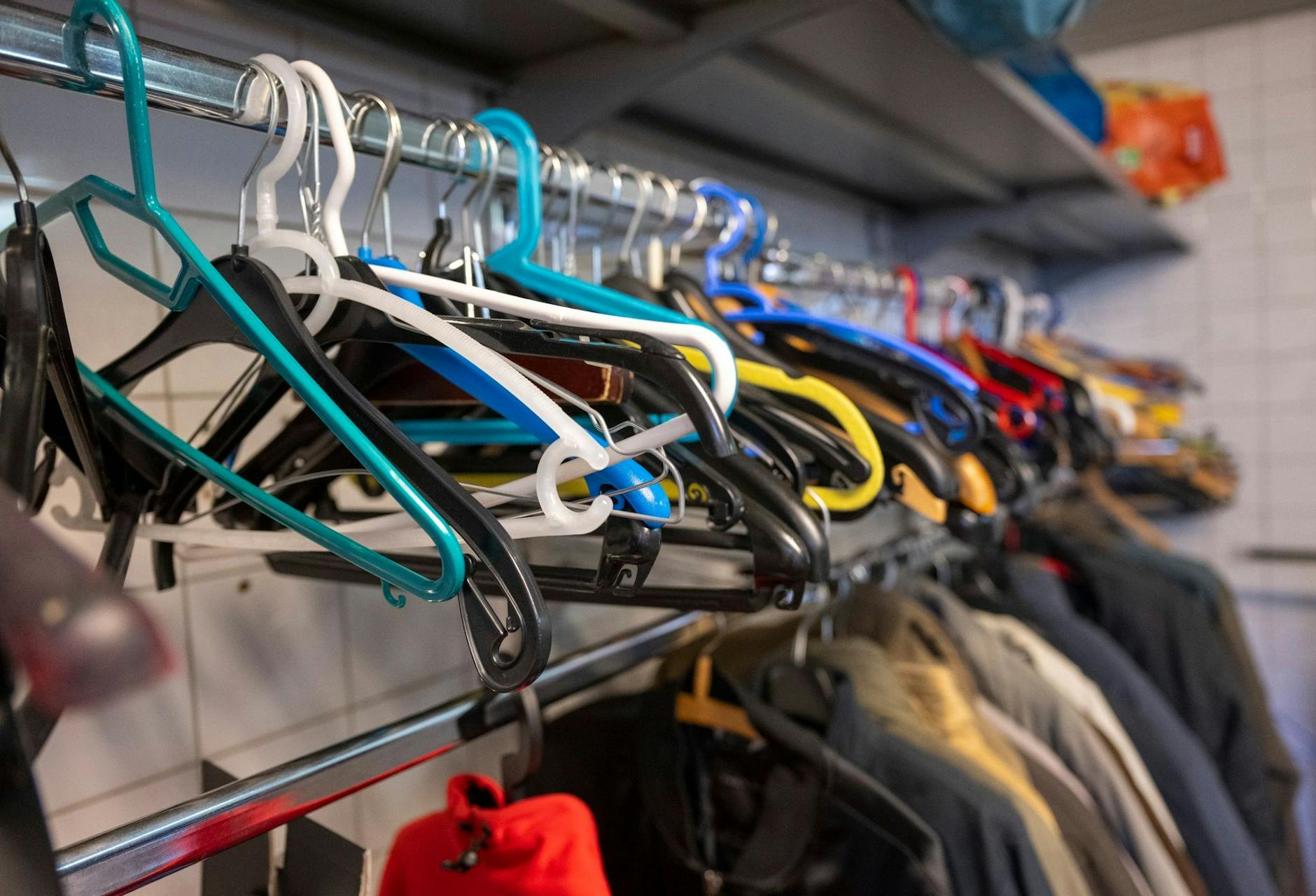 ARCHIV - Leere Kleiderbügel hängen an einer Stange in der Kleiderkammer der Berliner Stadtmission. d