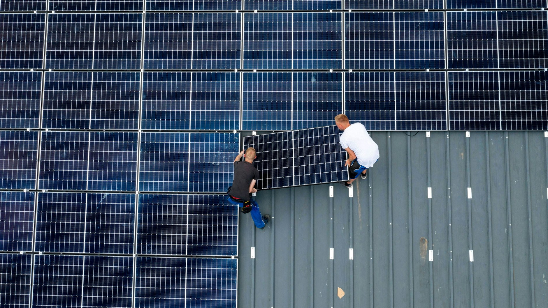 Montage von Solarmodulen auf das Dach einer Scheune. Um die Energiewende hinzukriegen, braucht es Menschen, die anpacken.&nbsp;