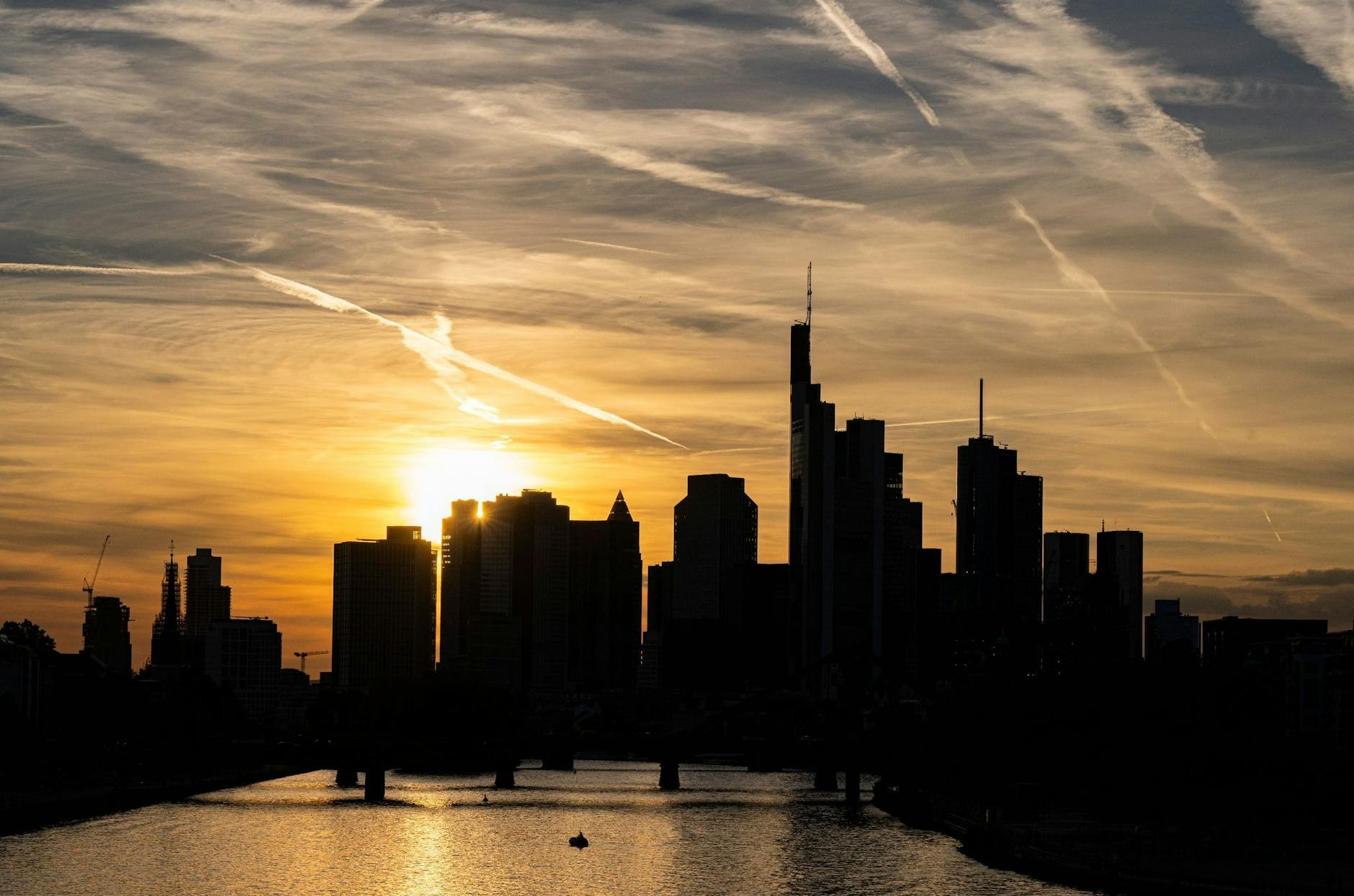 ARCHIV - Bankentürme der Frankfurter Skyline vor einem sonnengefärbten Himmel.