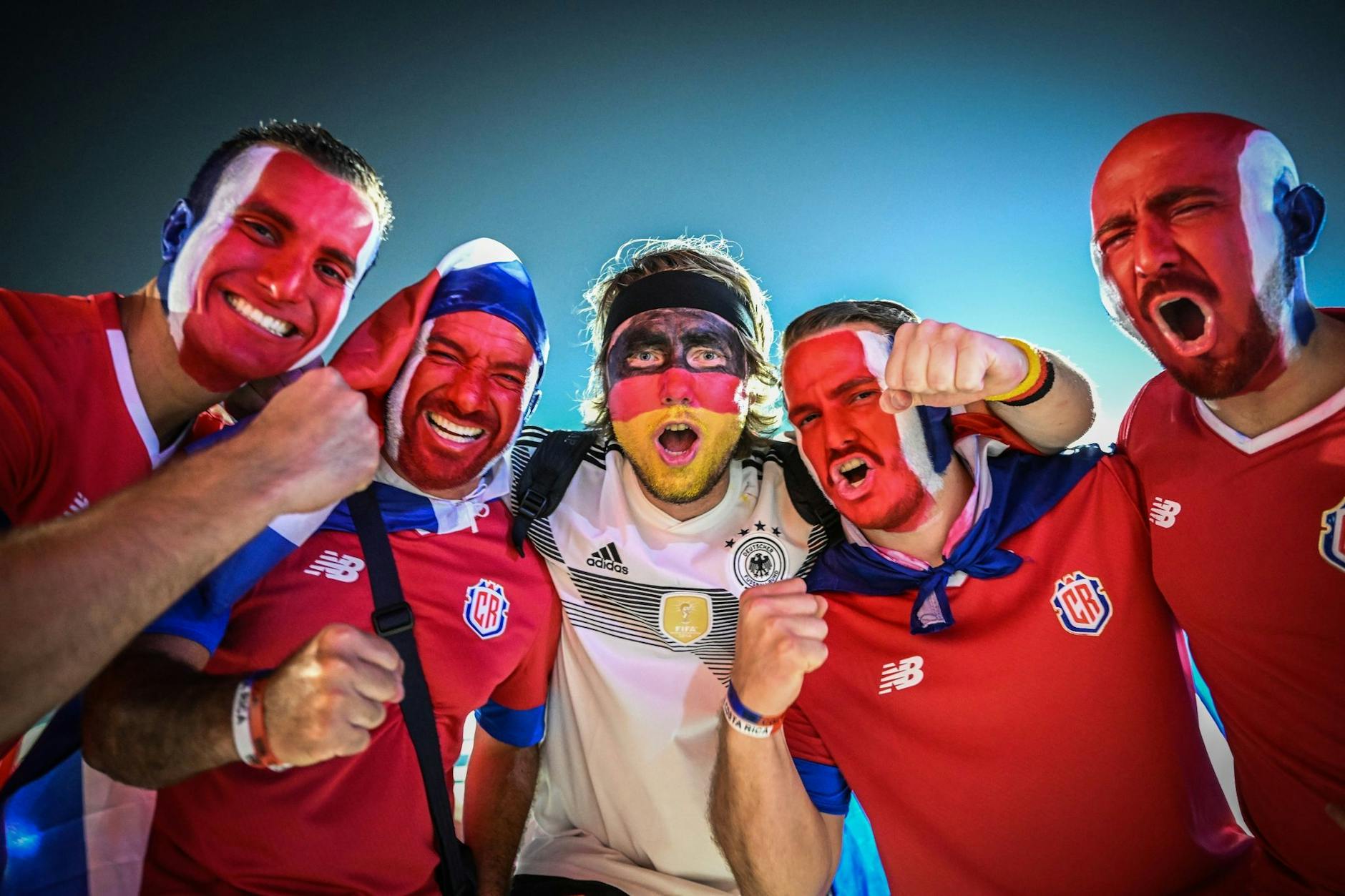 Vor der Begegnung Deutschland gegen Costa Rica bei der WM in Katar posieren Fans beider Mannschaften zusammen für ein Foto.