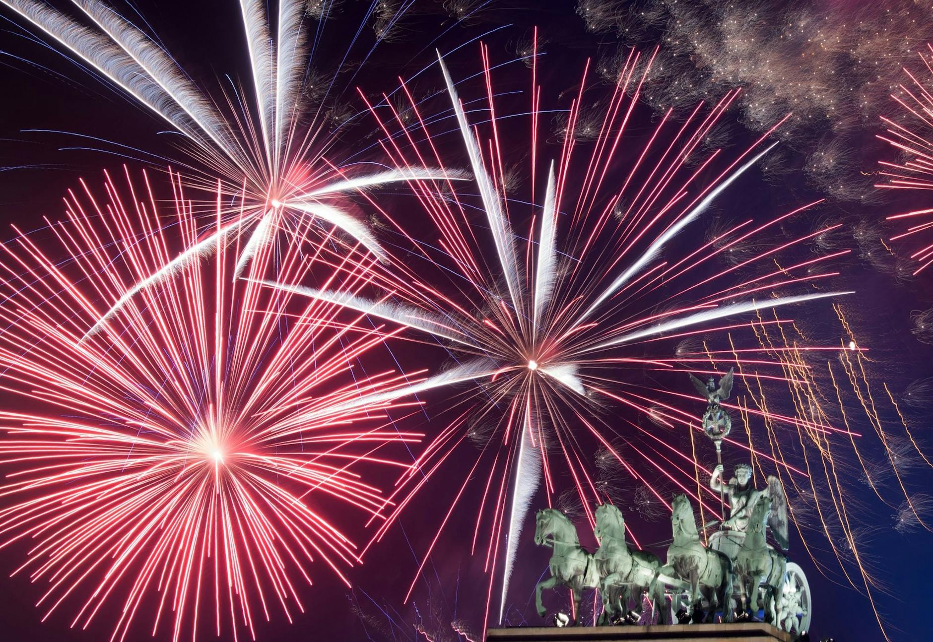 ARCHIV - Ein Feuerwerk ist während Deutschlands größter Silvesterparty hinter dem Brandenburger Tor zu sehen.