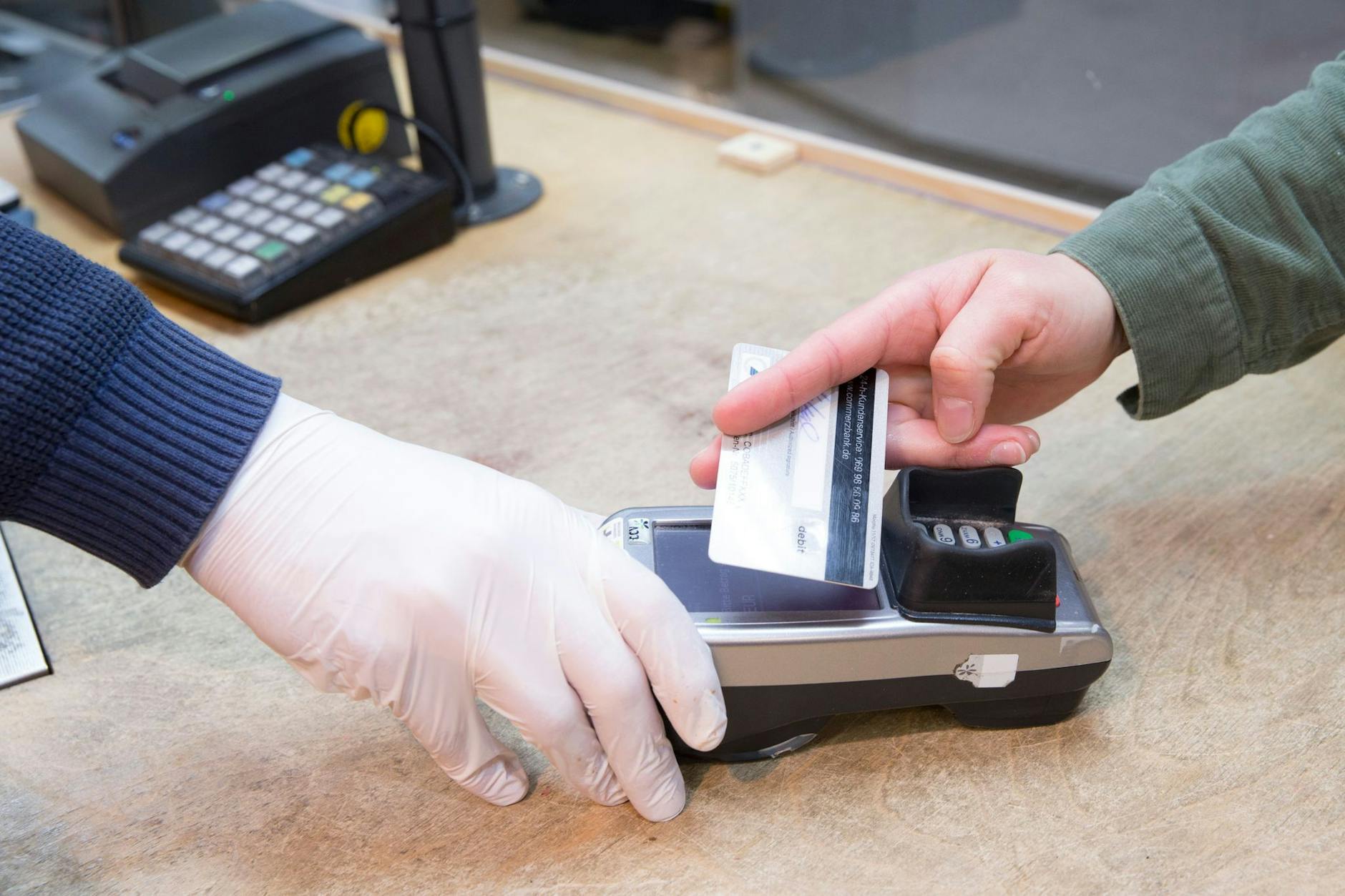 Ein Verkäufer hält einem Kunden das EC-Lesegerät zum kontaktlosen Bezahlen hin. Die Girocard soll aufgewertet werden. 