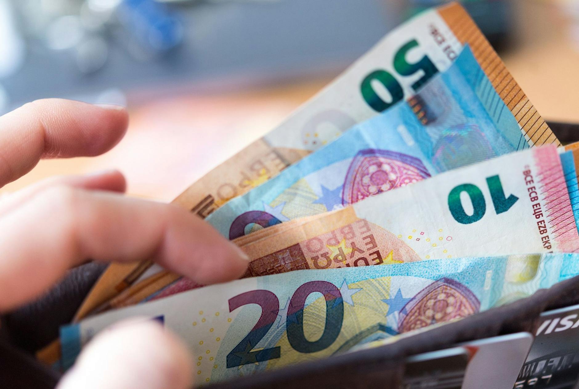 ARCHIV - Eine Frau hält eine Geldbörse mit Banknoten in der Hand. ld/dpa