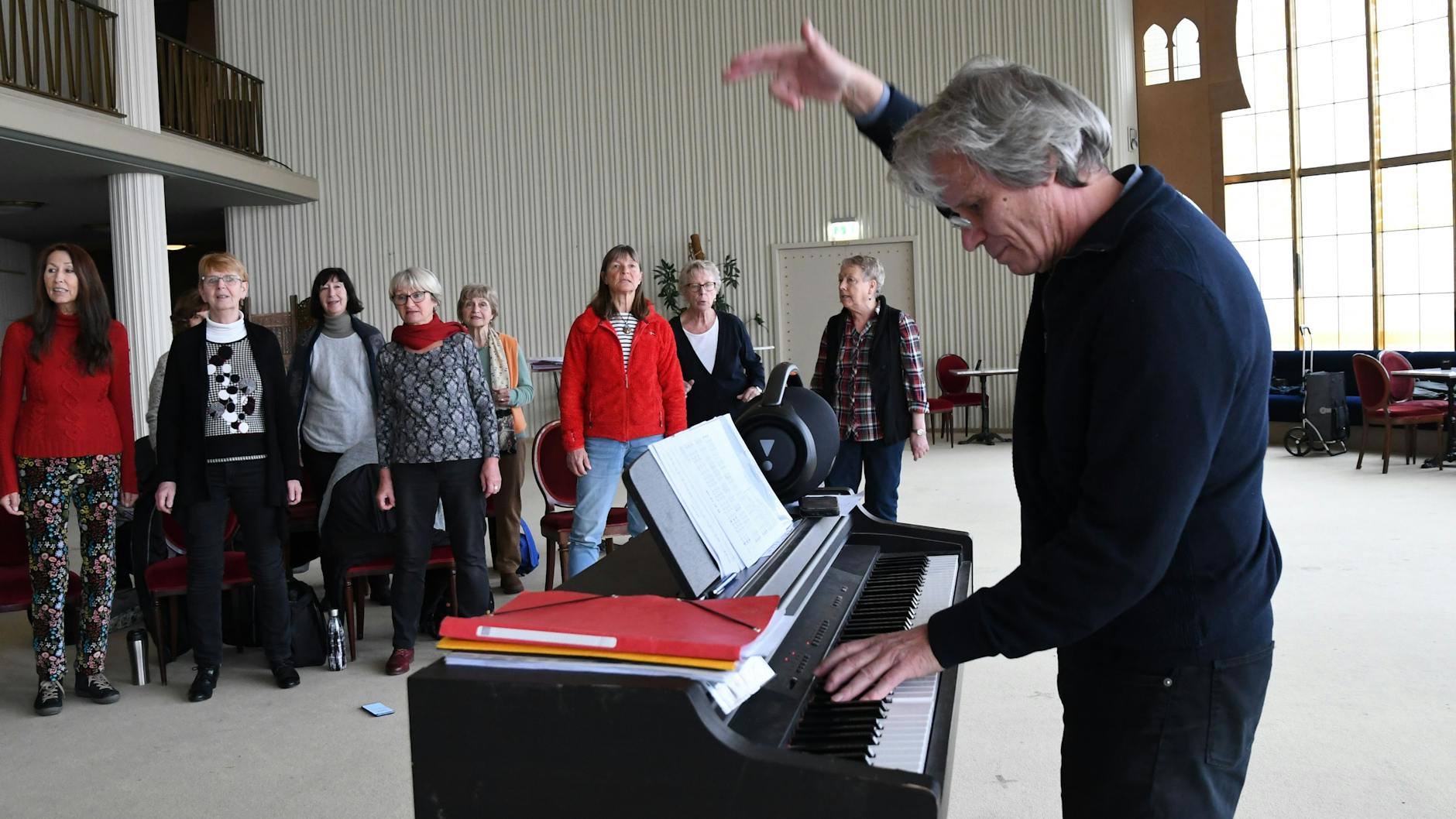  Chorleiter Wolfgang Thierfeldt dirigiert und übt die Songs am Klavier