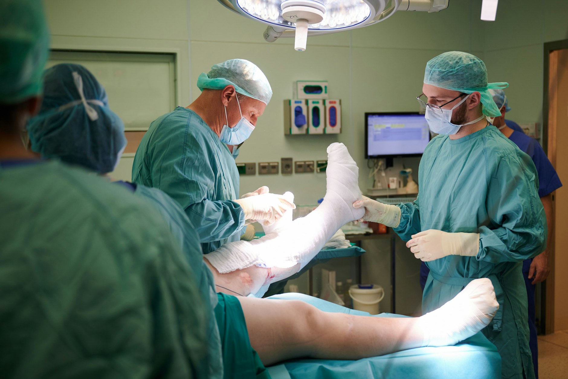 Der junge ukrainische Chirurg Olexander Jazkowyna (r.) hilft Frank Sander, stellvertretender Chefarzt im Brandverletzungszentrum, bei einer Operation im Unfallkrankenhaus Berlin.