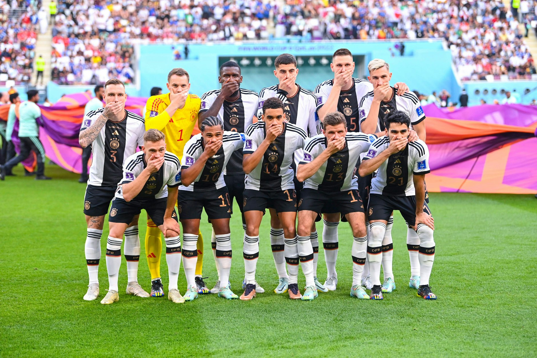 Die Spieler der deutschen Fußballnationalmannschaft halten sich den Mund zu.