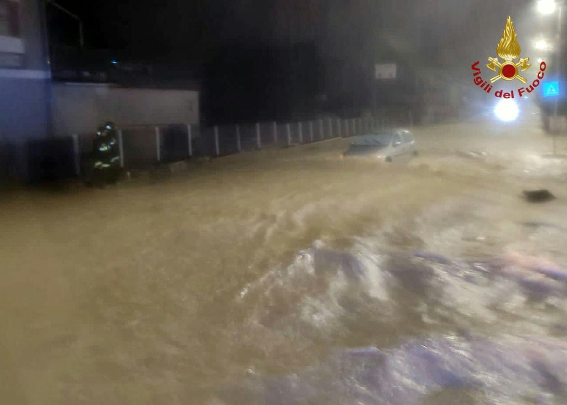 HANDOUT - Auf einer überfluteten Straße treibt ein Auto in Kalabrien durch die Wassermassen.