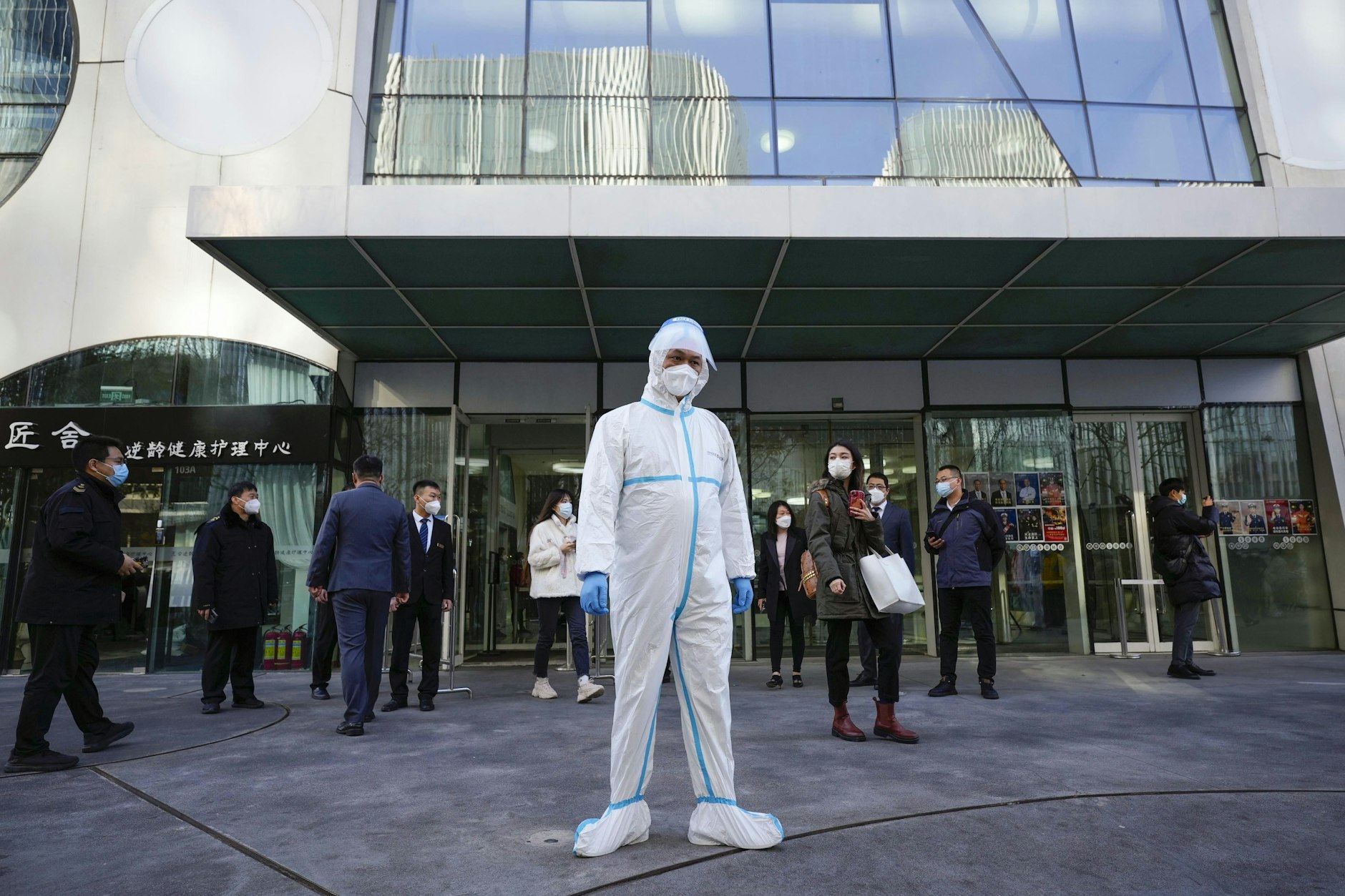 Ein Beamter in Schutzkleidung steht vor einem Gebäude, das im Rahmen der Null-COVID-19-Politik der chinesischen Regierung geschlossen wurde.