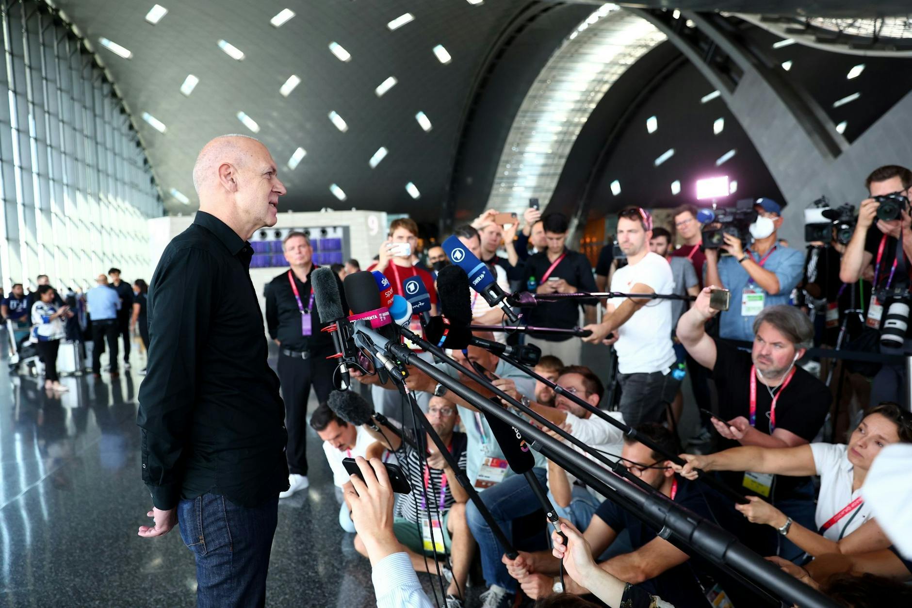 DFB-Präsident Bernd Neuendorf (l) gibt am Flughafen in Doha ein Statement.