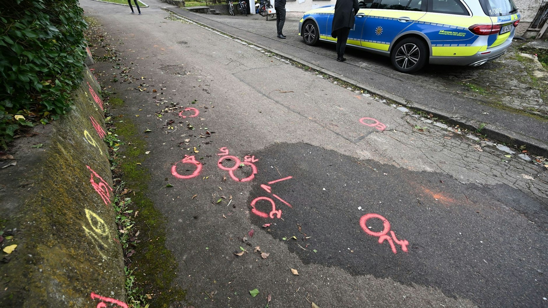Markierungen der Spurensicherung der Polizei sind am Tatort auf einem Weg angebracht. Foto:&nbsp;