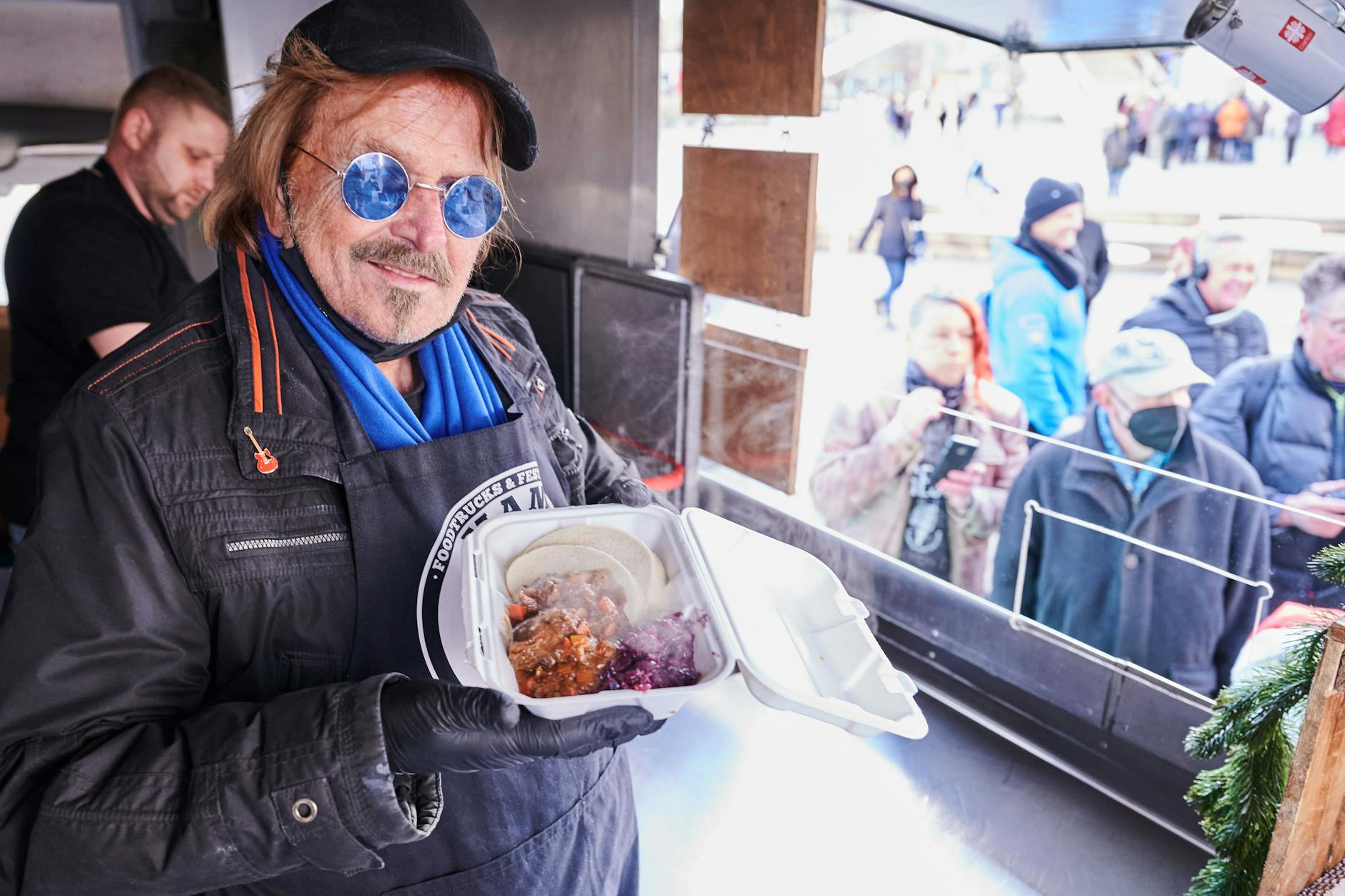 Frank Zander steht im Caritas-Foodtruck und verteilt warme Mahlzeiten an Obdachlose und bedürftige Menschen auf dem Alexanderplatz.