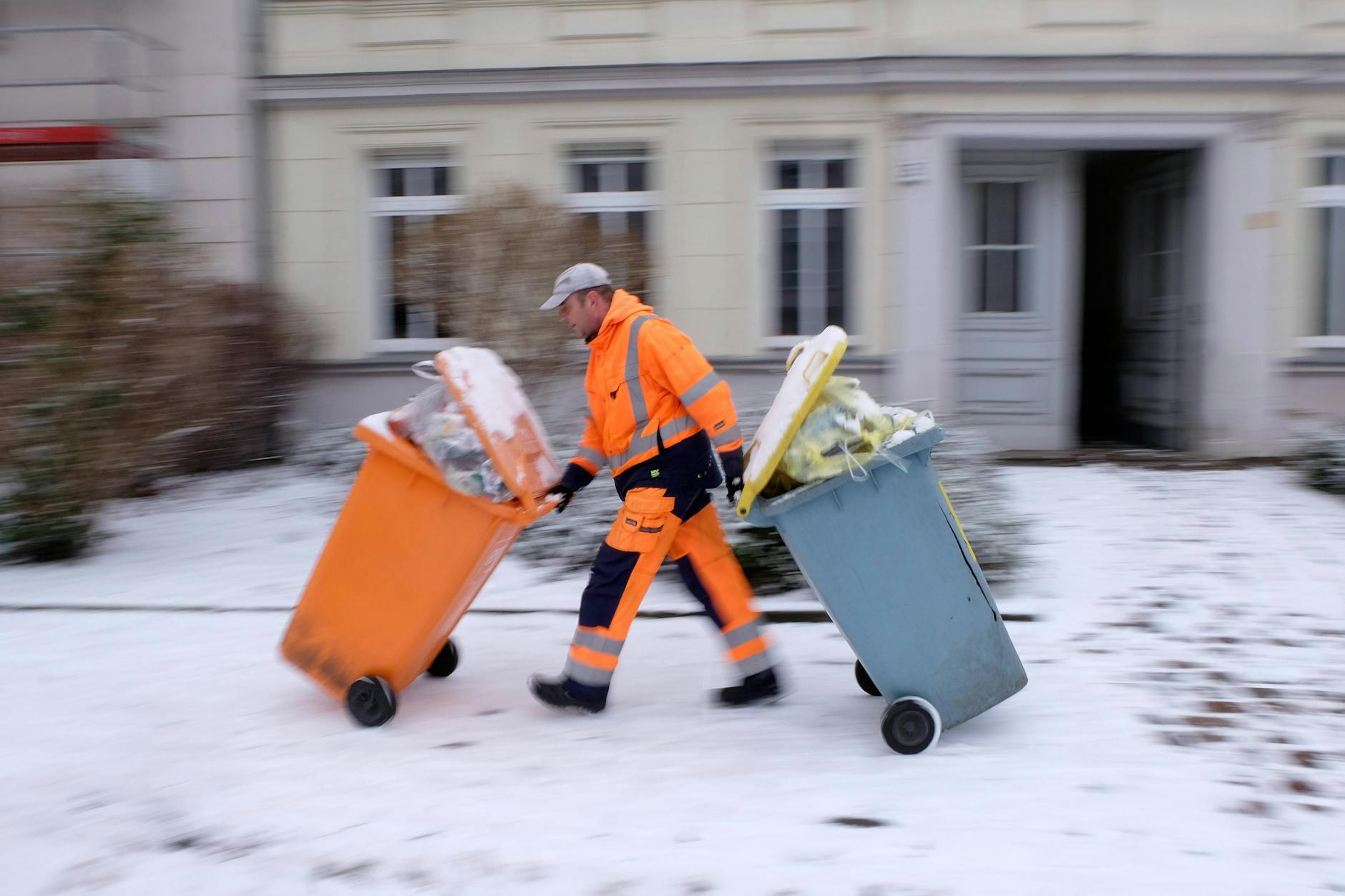 Mitarbeiter der Berliner Stadtreinigung (BSR) im Schnee in Berlin-Pankow