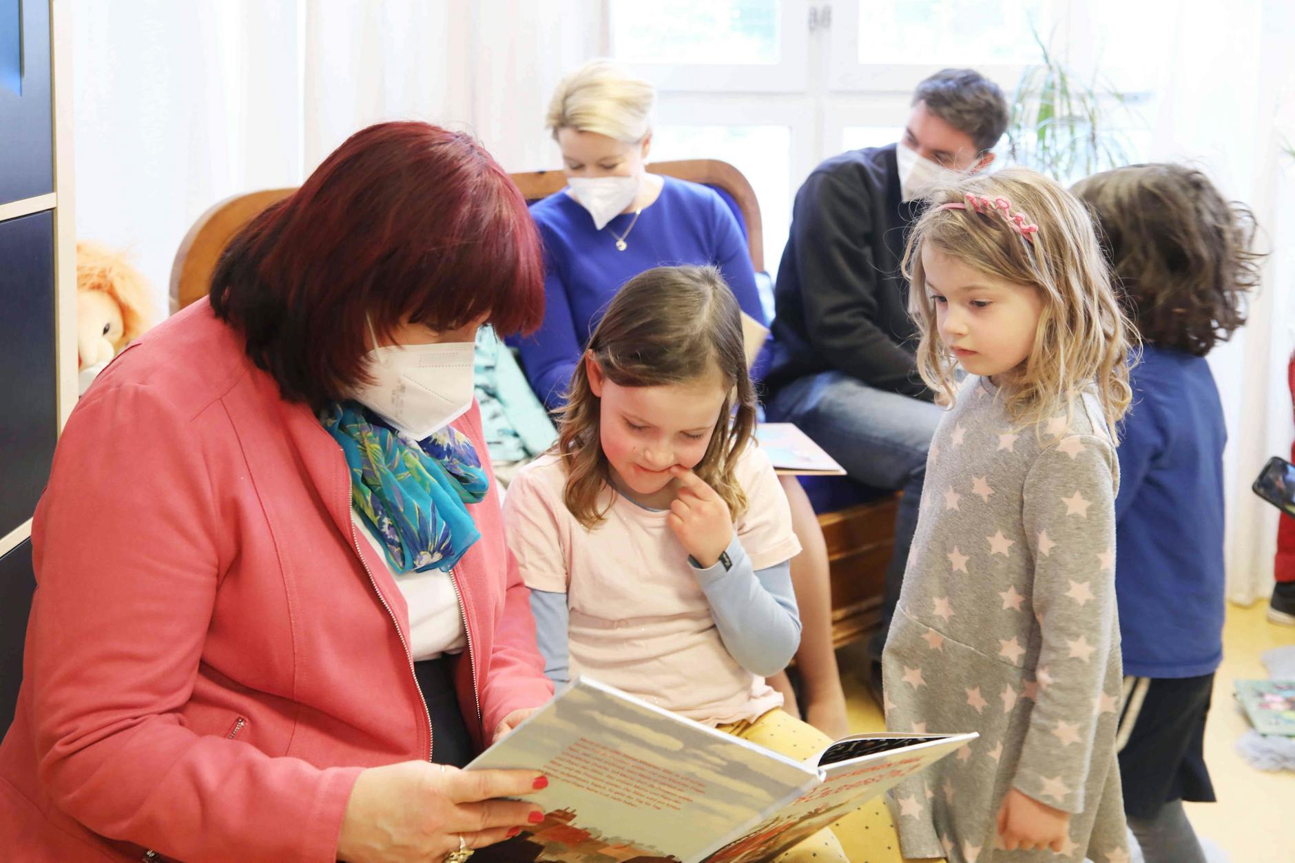 Bildungssenatorin Astrid-Sabine Busse (l.) liest Kitakindern etwas vor.