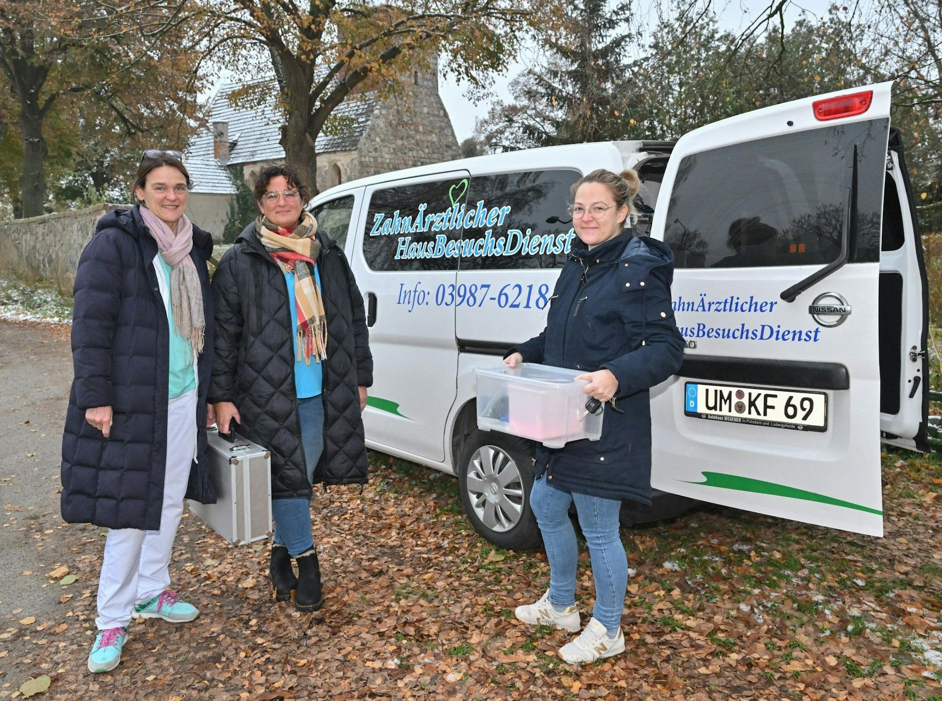 PRODUKTION - Kerstin Finger (l), Zahnärztin, sowie die beiden Zahnmedizinischen Fachangestellten stehen vor ihrem Fahrzeug.