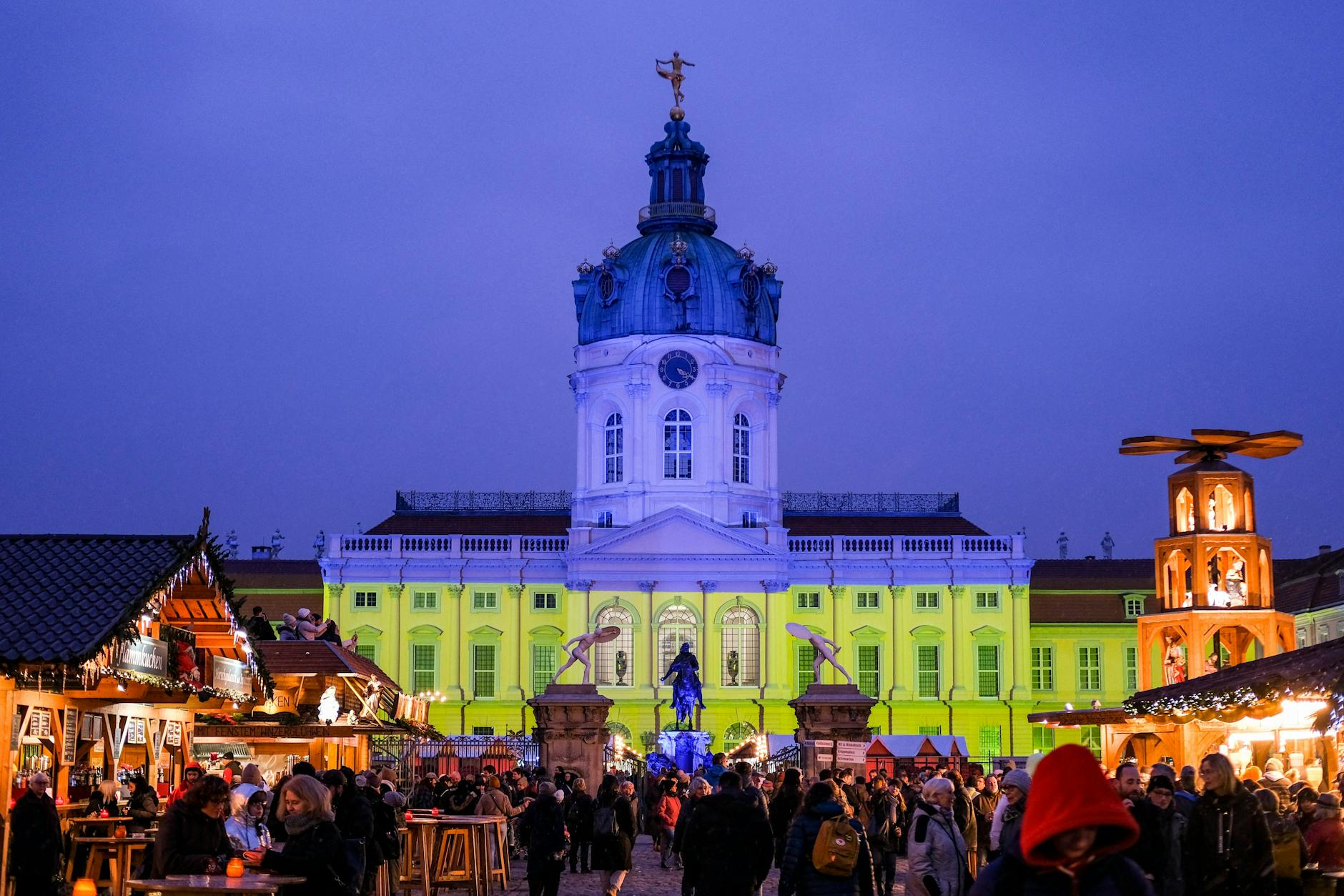 Hingucker: Die Fassade vom Schloss Charlottenburg wird während des Weihnachtsmarkts auch mit den Farben der ukrainischen Flagge in Blau und Gelb beleuchtet.