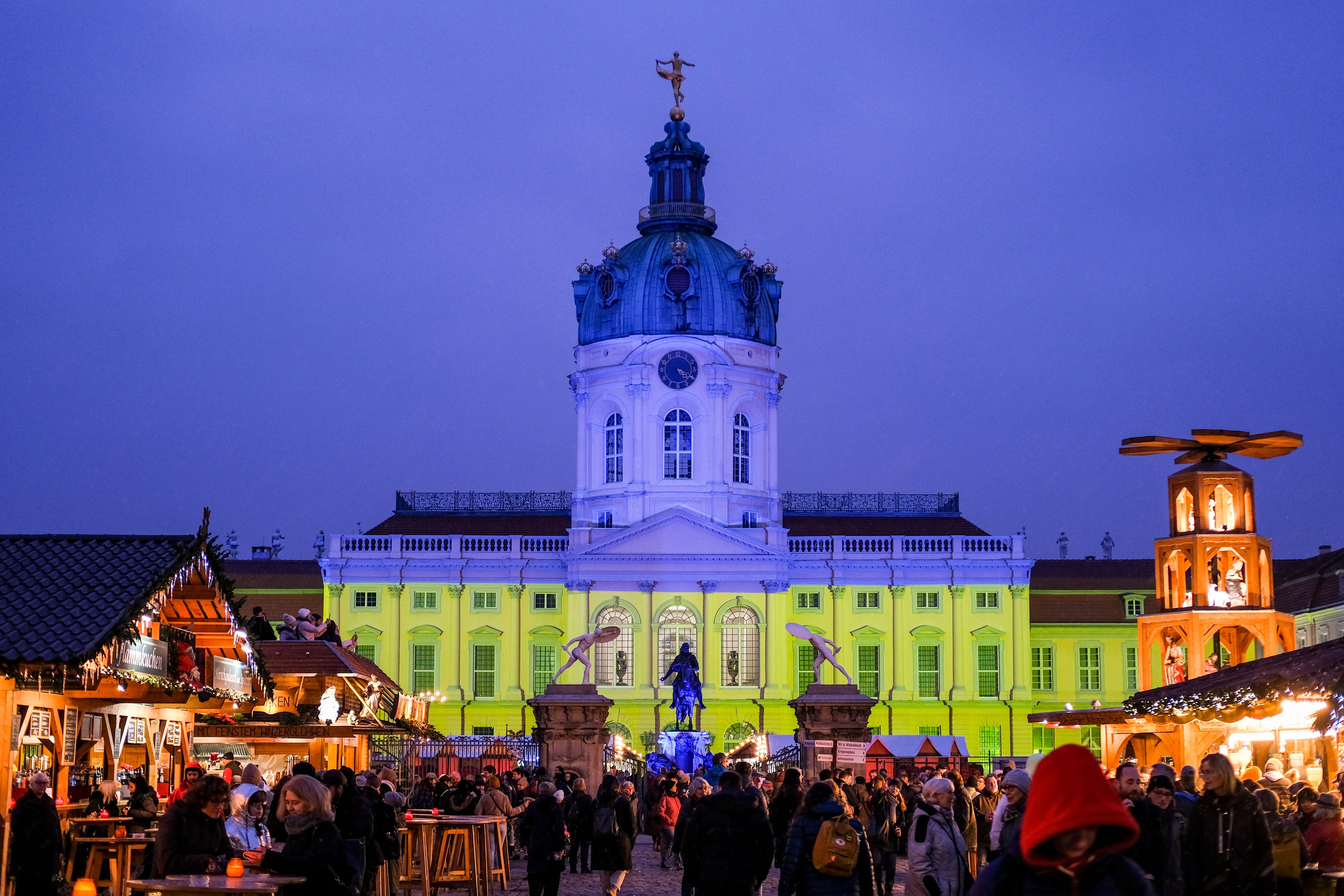 Hingucker: Die Fassade vom Schloss Charlottenburg wird während des Weihnachtsmarkts auch mit den Farben der ukrainischen Flagge in Blau und Gelb beleuchtet.