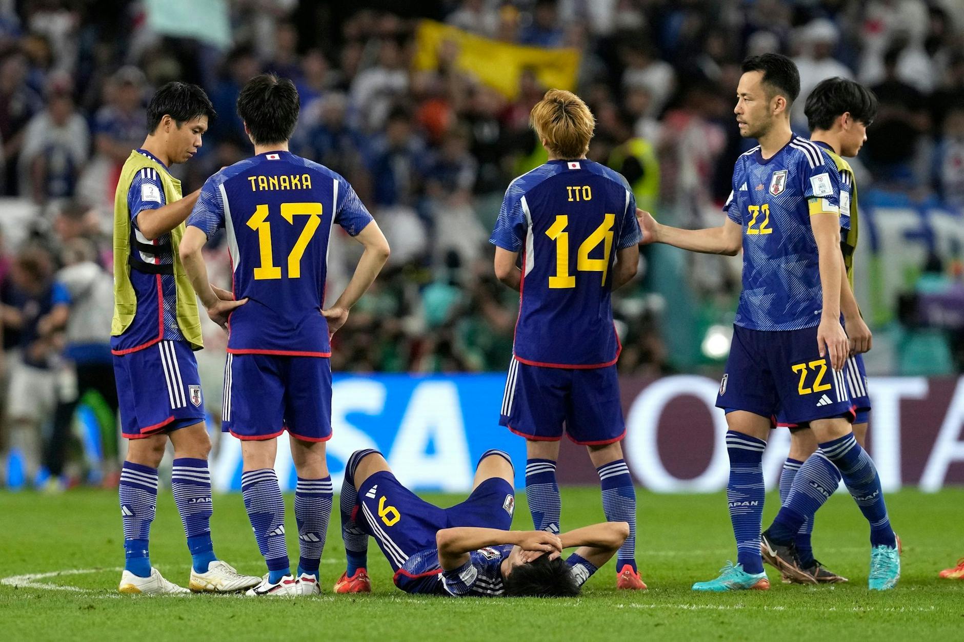 Japans Spieler stehen nach dem entscheidenden Elfmeter auf dem Platz.