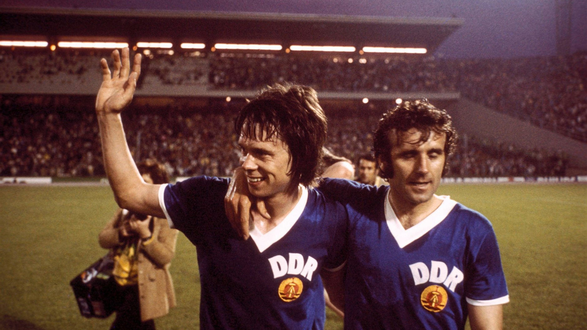 Nach dem 1:0 gegen die BRD: DDR-Torschütze Jürgen Sparwasser (l.) verlässt zufrieden mit Spieler-Kollege Erich Hamann das Hamburger Volksparkstadion.