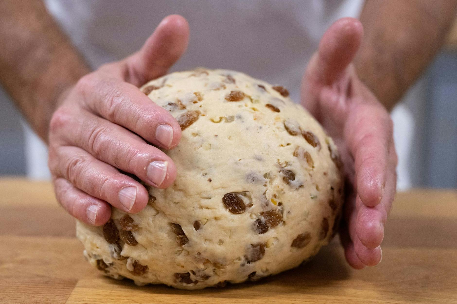  Ein Bäckermeister formt einen Teigling. Unternehmen in Deutschland brauchen Fachkräfte.