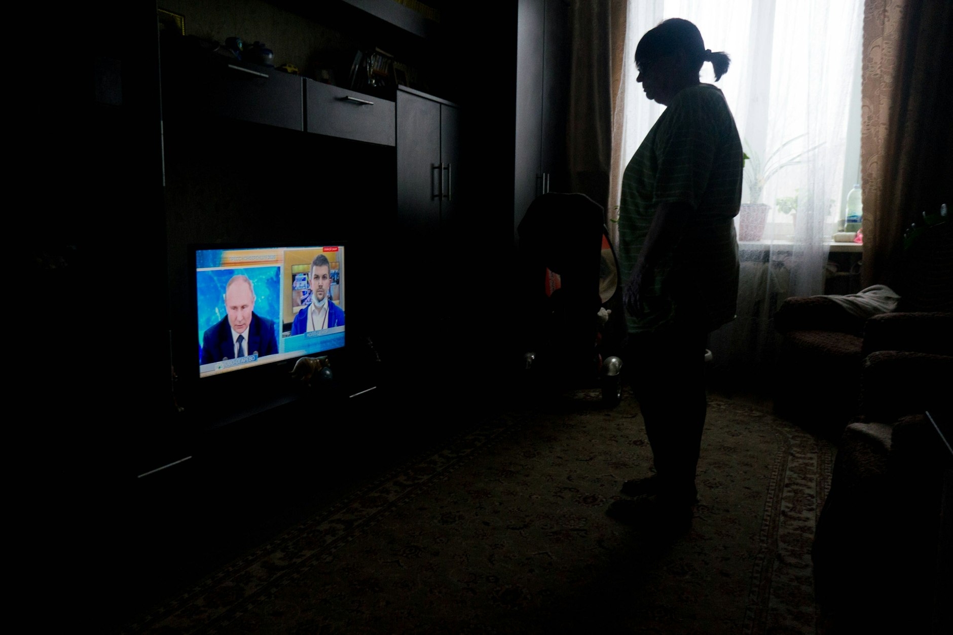 Eine Frau verfolgt im russischen Staatsfernsehen eine Rede des russischen Präsidenten Wladimir Putin.
