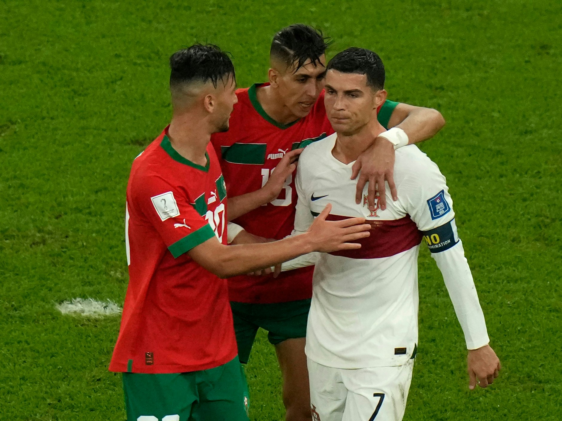 Die marokkanischen Spieler Achraf Dari (l.) and Jawad El-Yamiq versuchen, den fassungslosen Cristiano Ronaldo zu trösten.