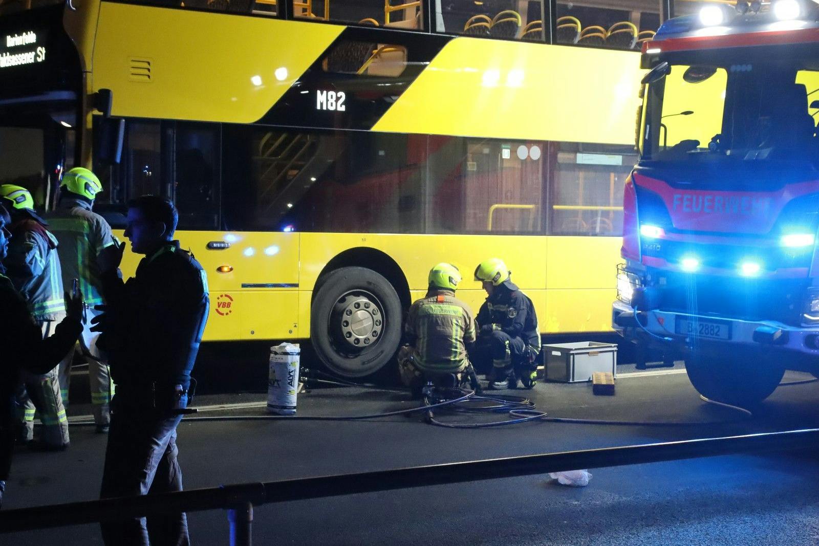 Die Rüstgruppe der Feuerwehr arbeitet daran, den BVG-Bus anzuheben. Unter dem Fahrzeug wurden zwei Jugendliche eingeklemmt. 