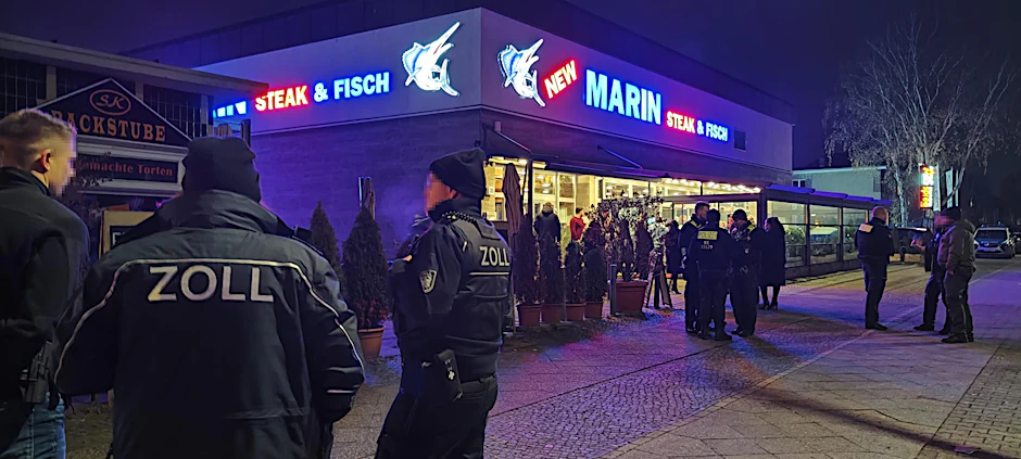 Beamte von Zoll und Polizei stehen vor dem Neuköllner Restaurant New Marin Steak & Fish.