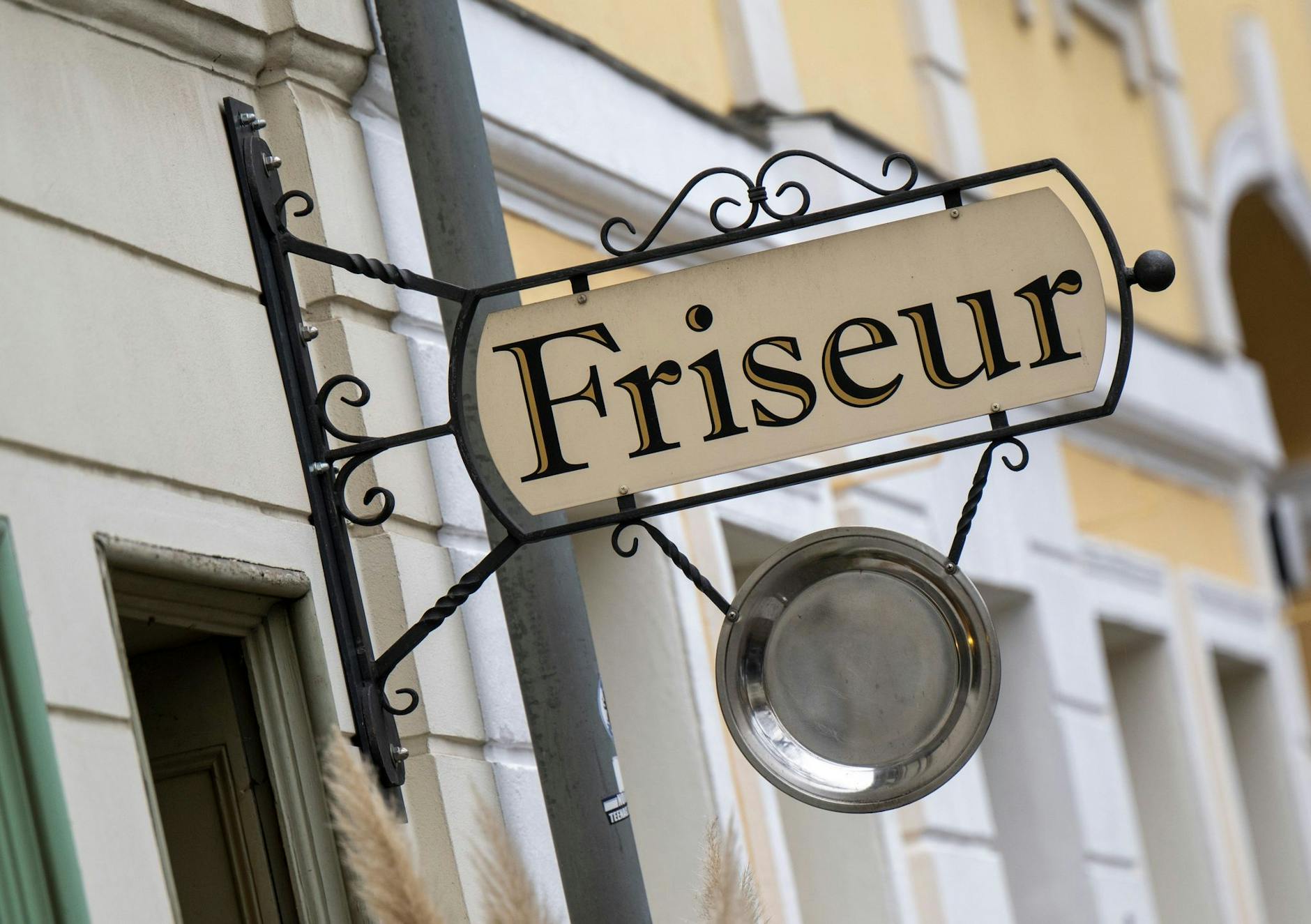 ARCHIV - Ein Schild hängt über dem Eingang zu einem Friseursalon in der Potsdamer Innenstadt. ld/dpa/Archivbild